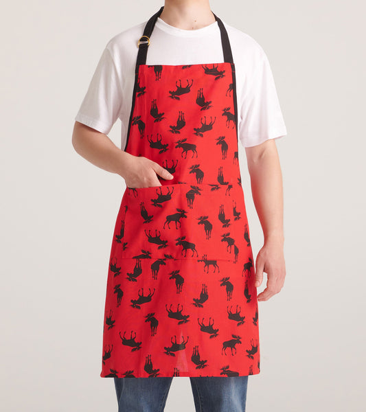 Red apron featuring a moose pattern, with a front pocket and adjustable neck strap. One size fits all.