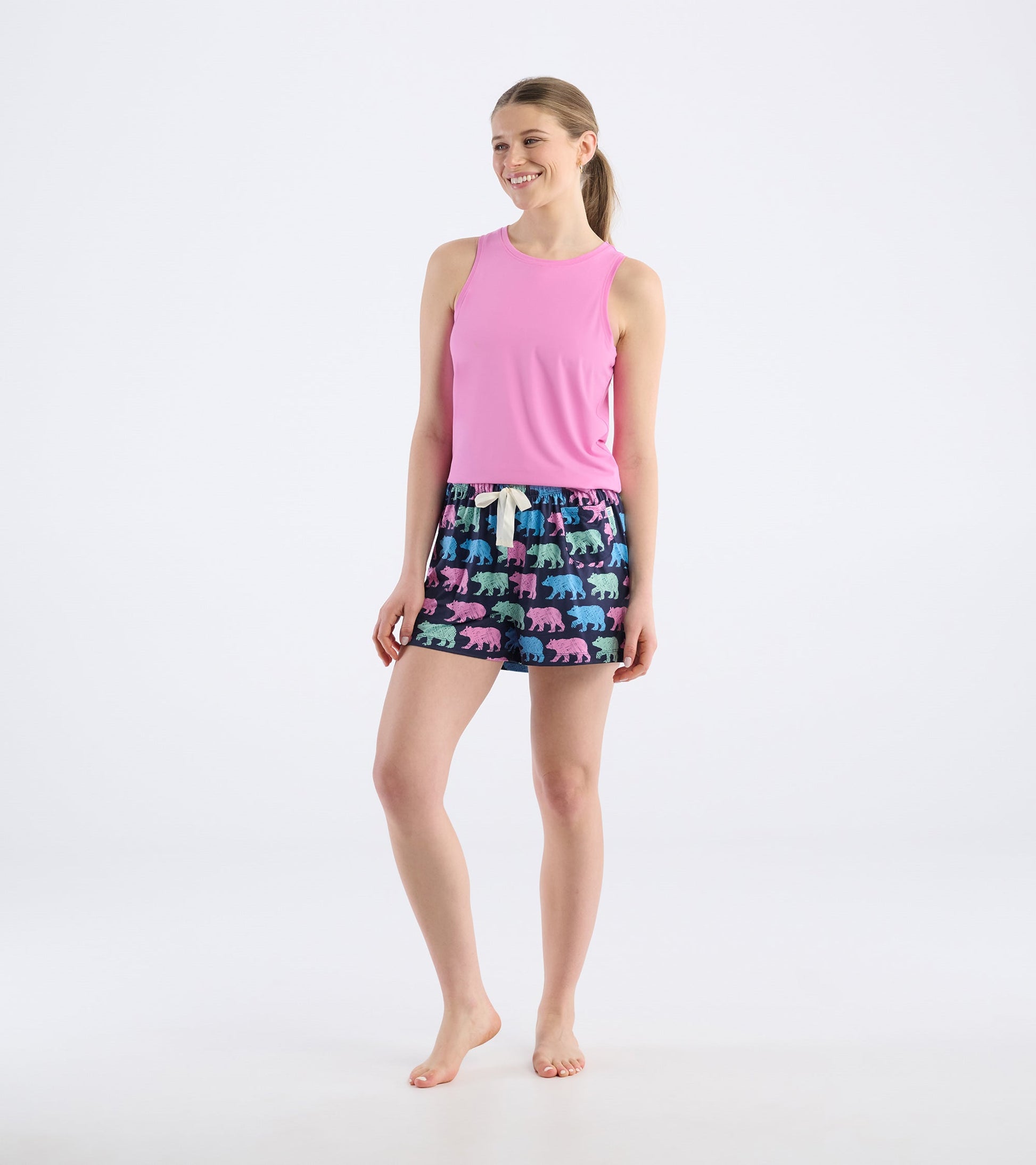 Colorful pajama shorts featuring bear patterns on a dark background, paired with a pink tank top.