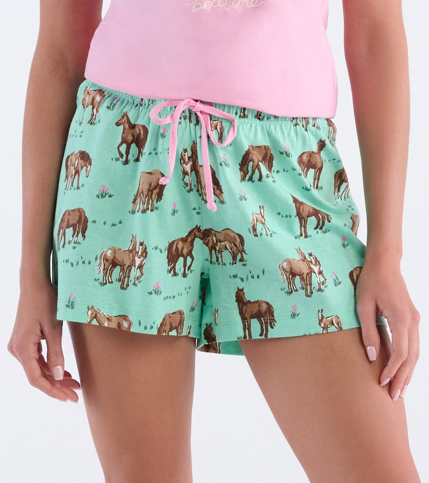 Mint green cotton pajama shorts featuring a playful horse print and a drawstring waist.
