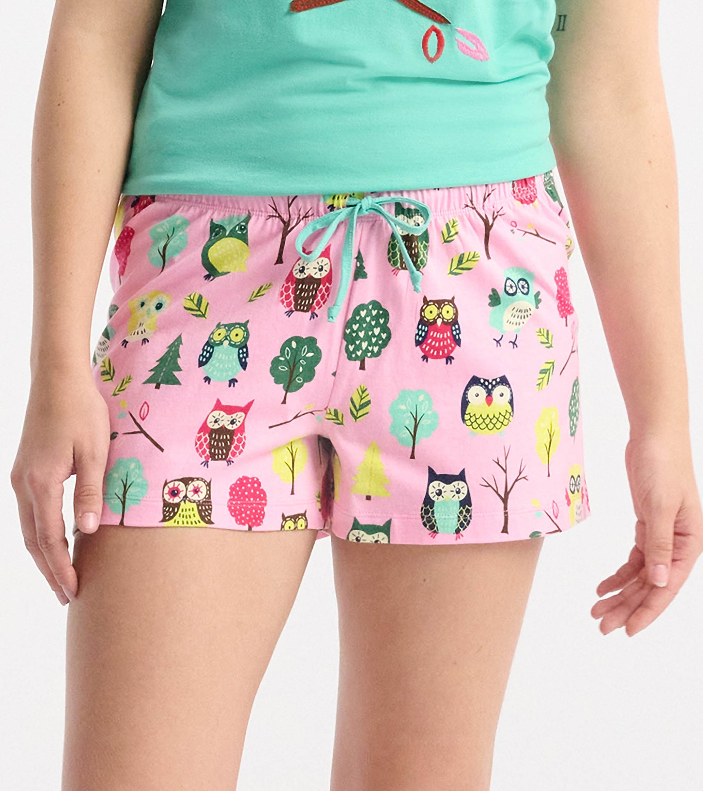 Pink cotton sleep shorts featuring a colorful owl and tree pattern, with an elastic waistband and drawstring.