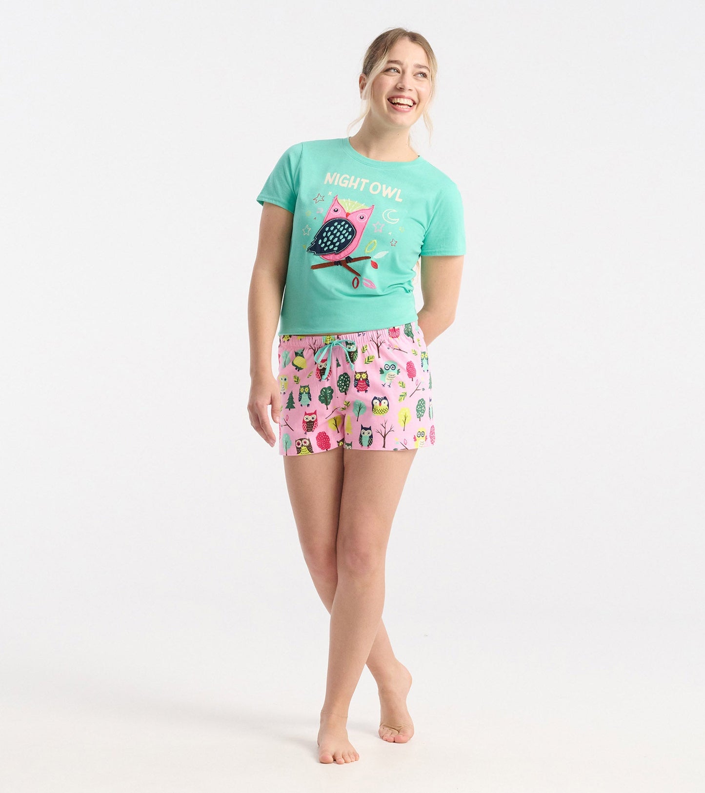 Pink cotton sleep shorts featuring colorful owl and tree patterns, with an elastic waistband and drawstring.