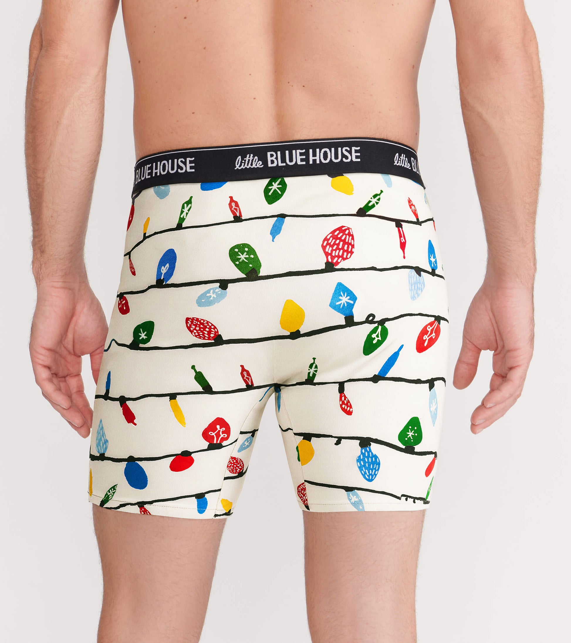 Men's boxer briefs featuring a festive pattern of colorful Christmas lights on a cream background, viewed from the back.