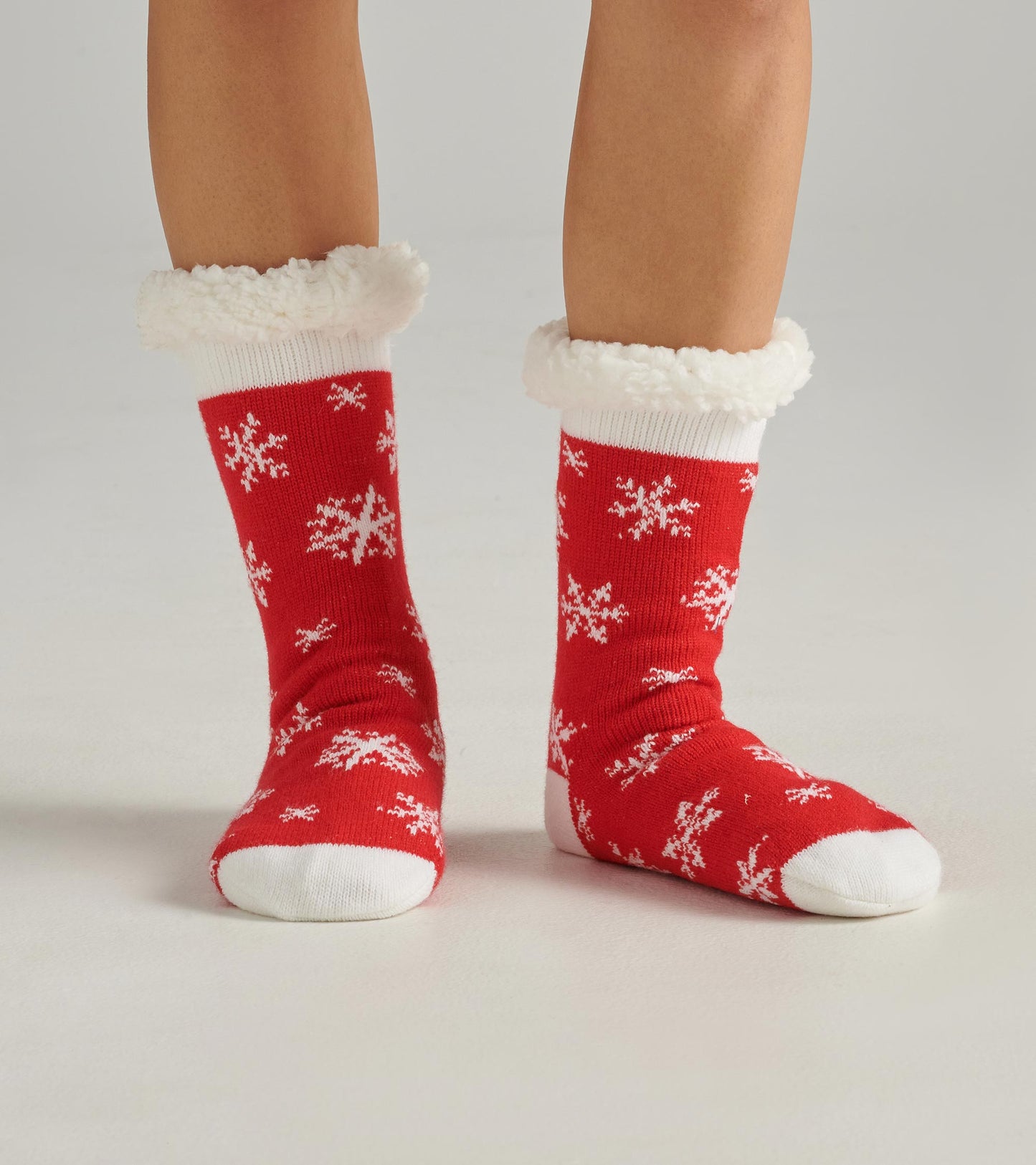 Red cabin socks with white snowflake pattern and fluffy white cuffs, designed for warmth and comfort.