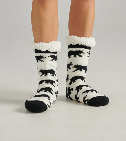 Black and white cabin socks with bear patterns and a fluffy white cuff, designed for warmth and comfort.