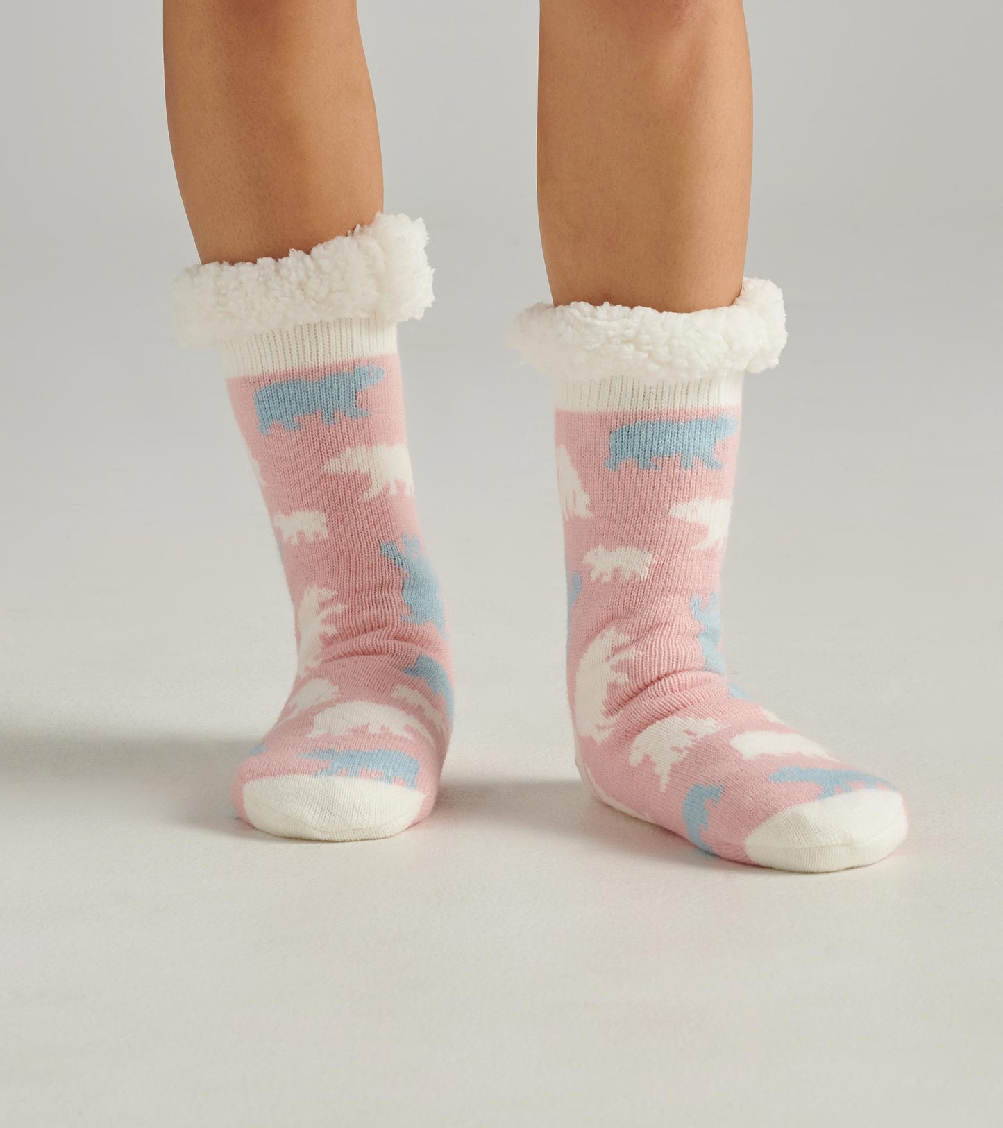 Pink cabin socks with polar bear patterns and a fluffy white cuff, designed for warmth and comfort.