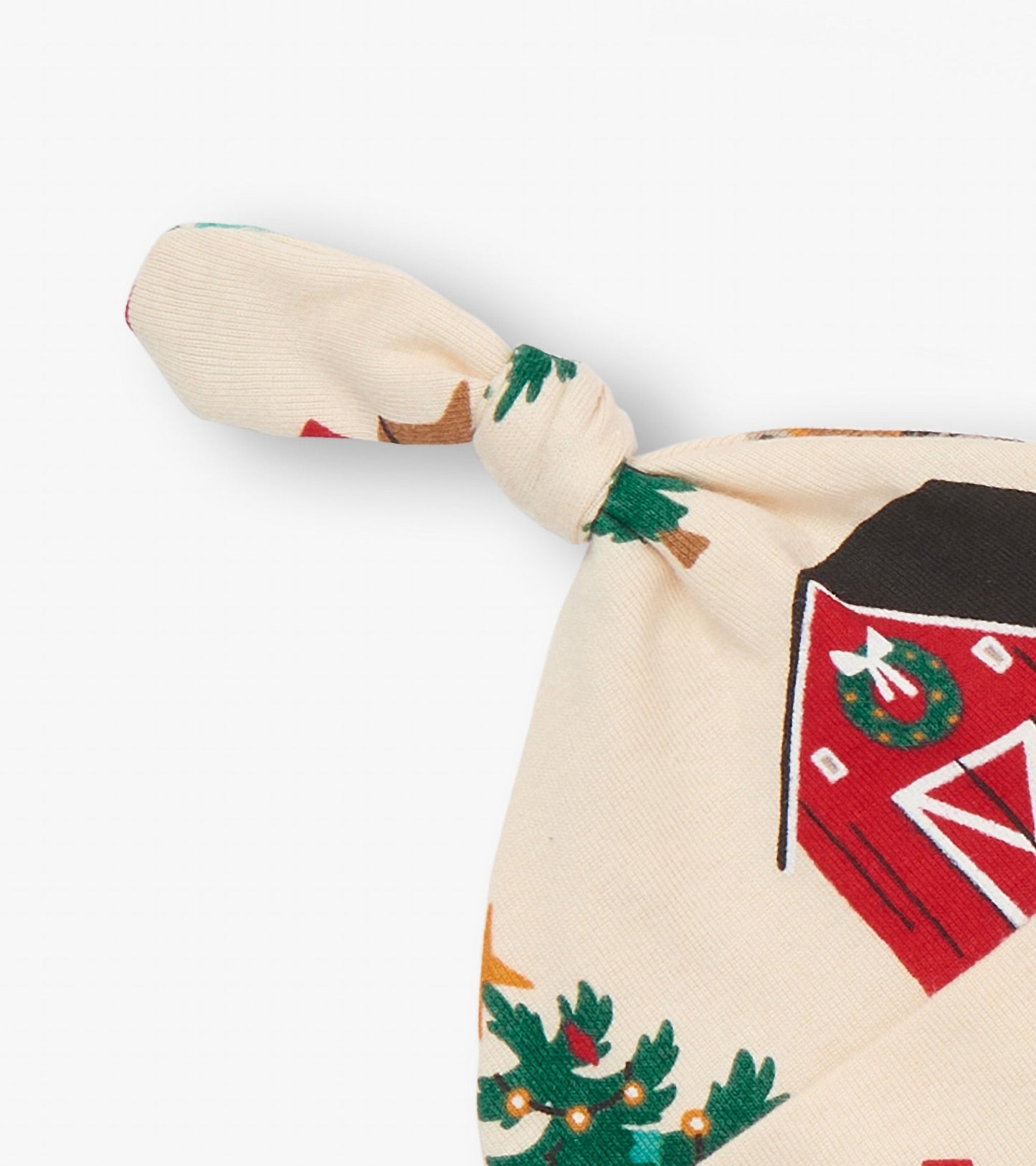 Cream-colored baby hat with a knot, featuring a festive Christmas tree farm print.
