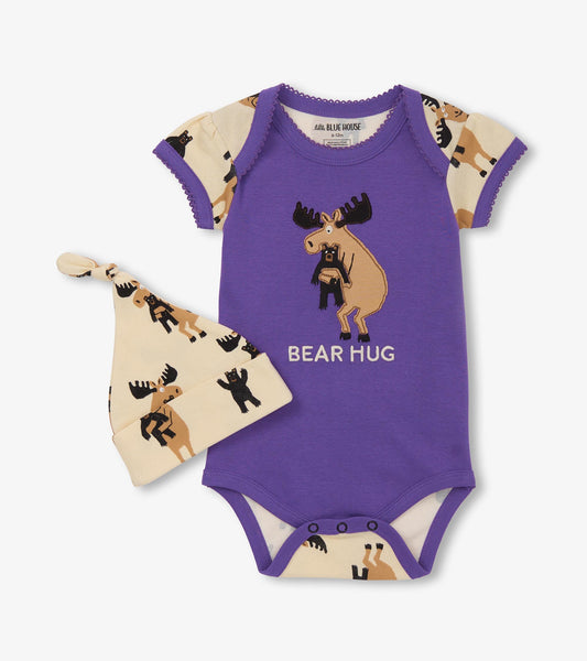Purple bodysuit with moose and bear design, paired with a matching cream hat featuring similar patterns.