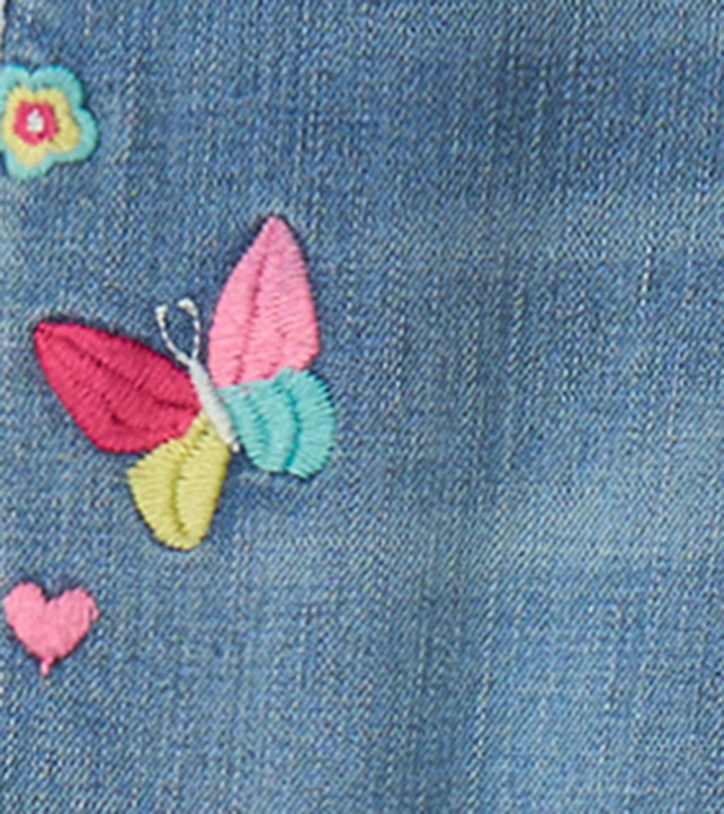 Light blue stretch jeans featuring colorful embroidered patches of a butterfly and flowers.