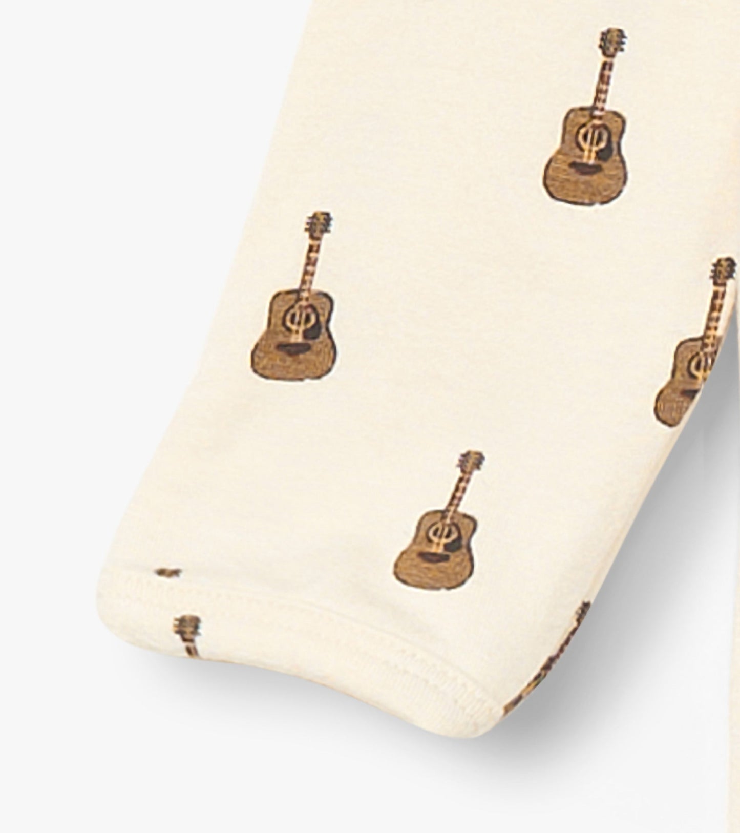 Cream bamboo sleeper featuring a playful guitar print, suitable for baby boys.