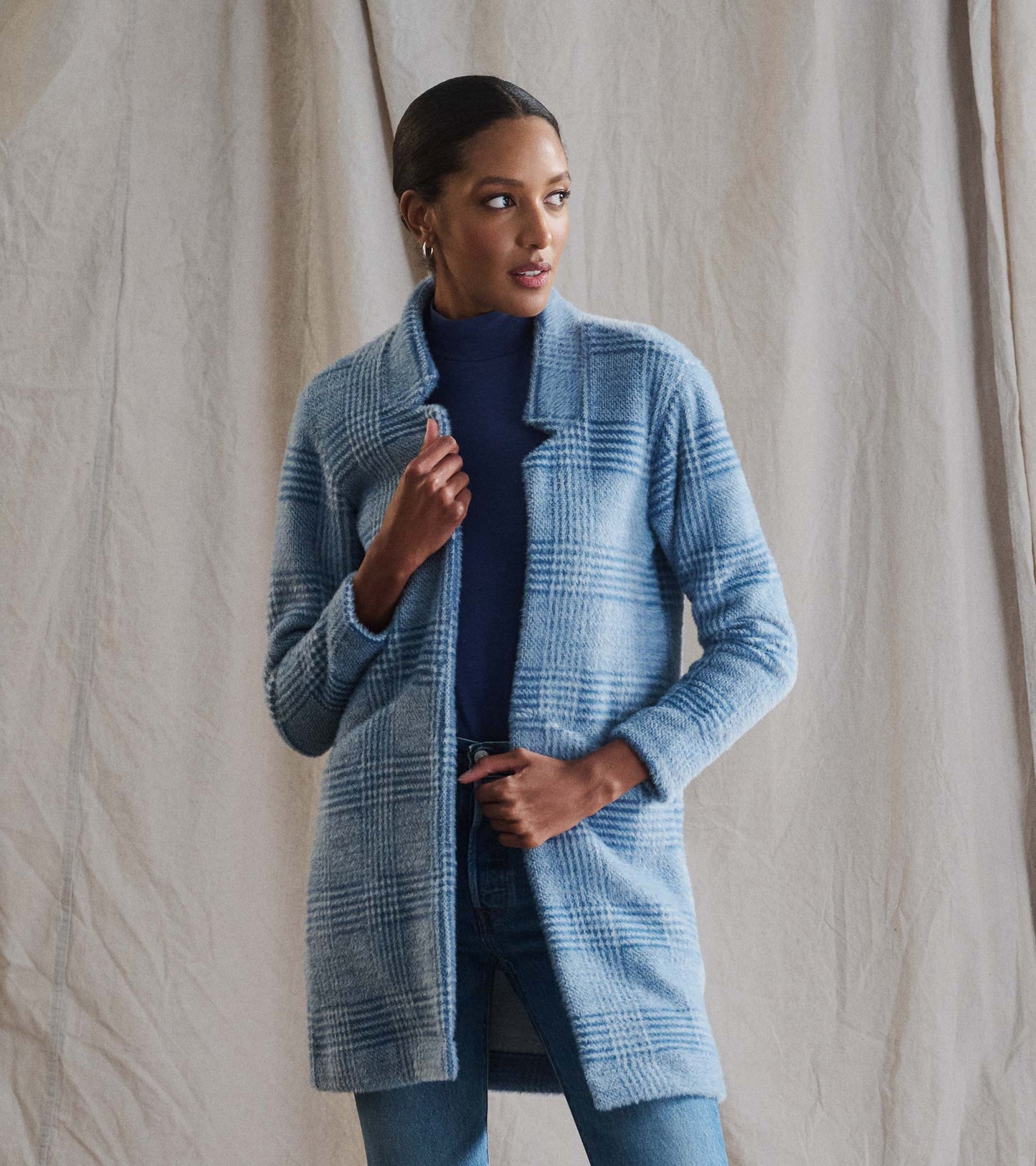 Open front jacket in blue check pattern, featuring long sleeves and a relaxed fit, styled over a turtleneck.