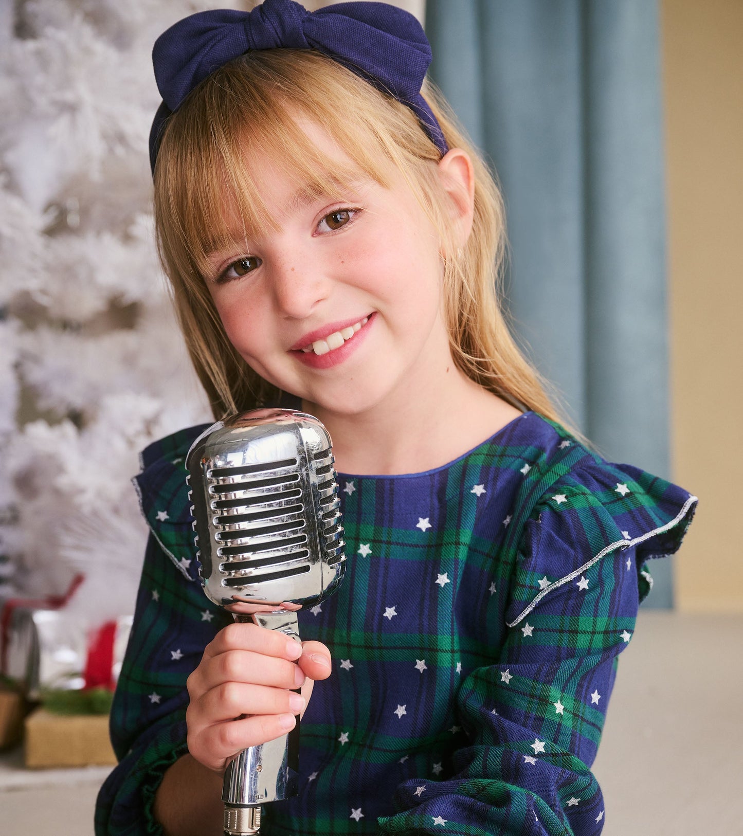 Girls' blackwatch plaid dress with smocked waist and ruffled sleeves, featuring green and navy colors with white stars.