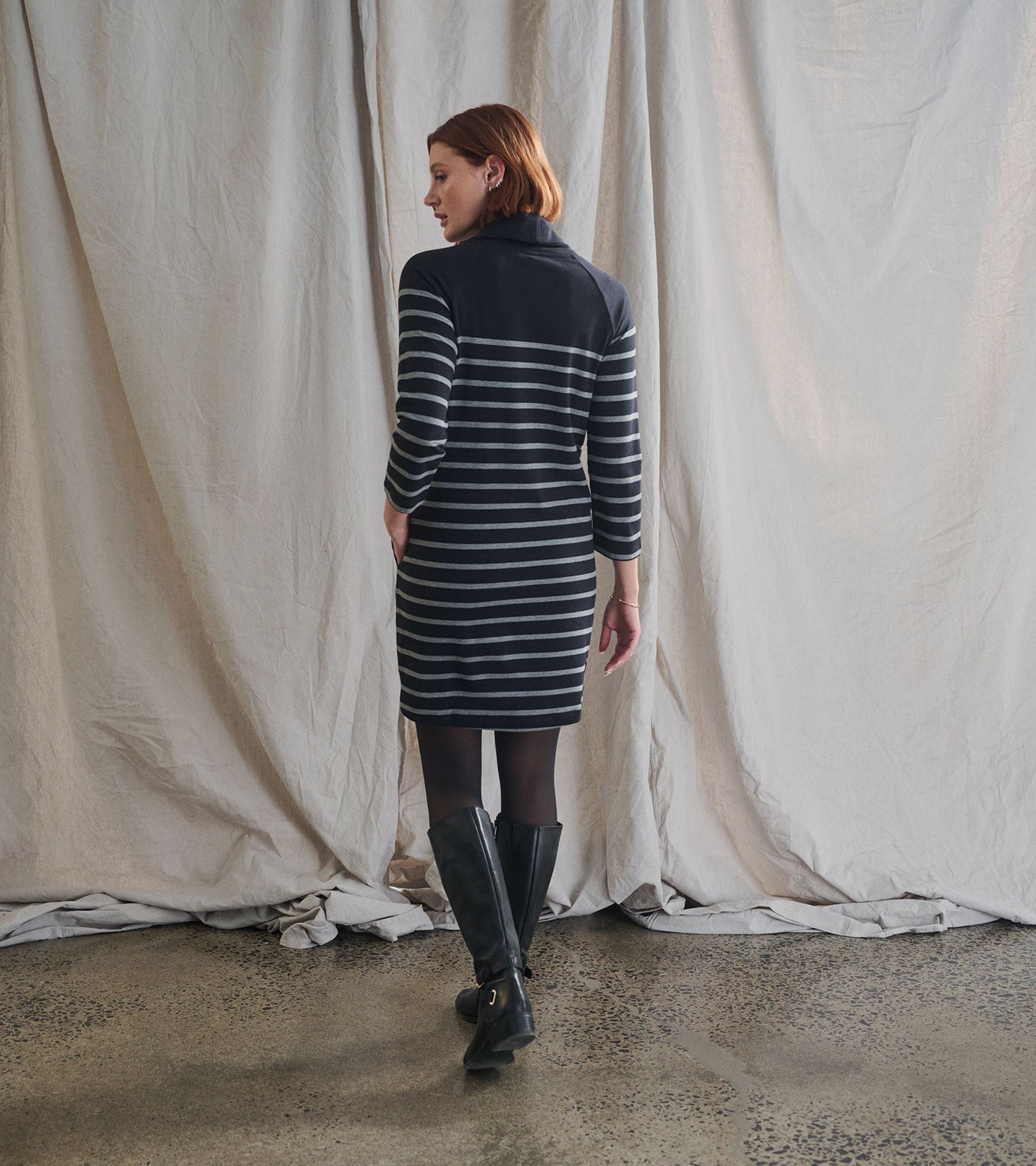 Draped collar dress in black with gray stripes, featuring long sleeves and a fitted silhouette, viewed from the back.
