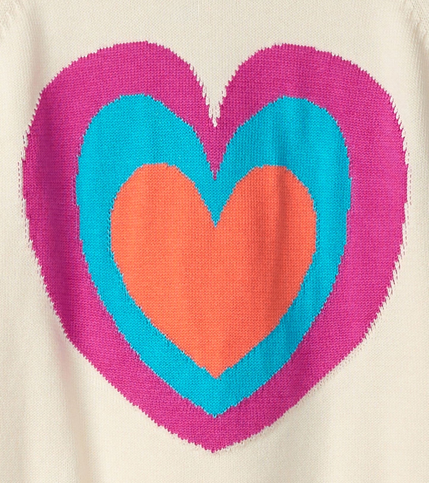 Cream sweater featuring a large, layered heart design in pink, blue, and orange.