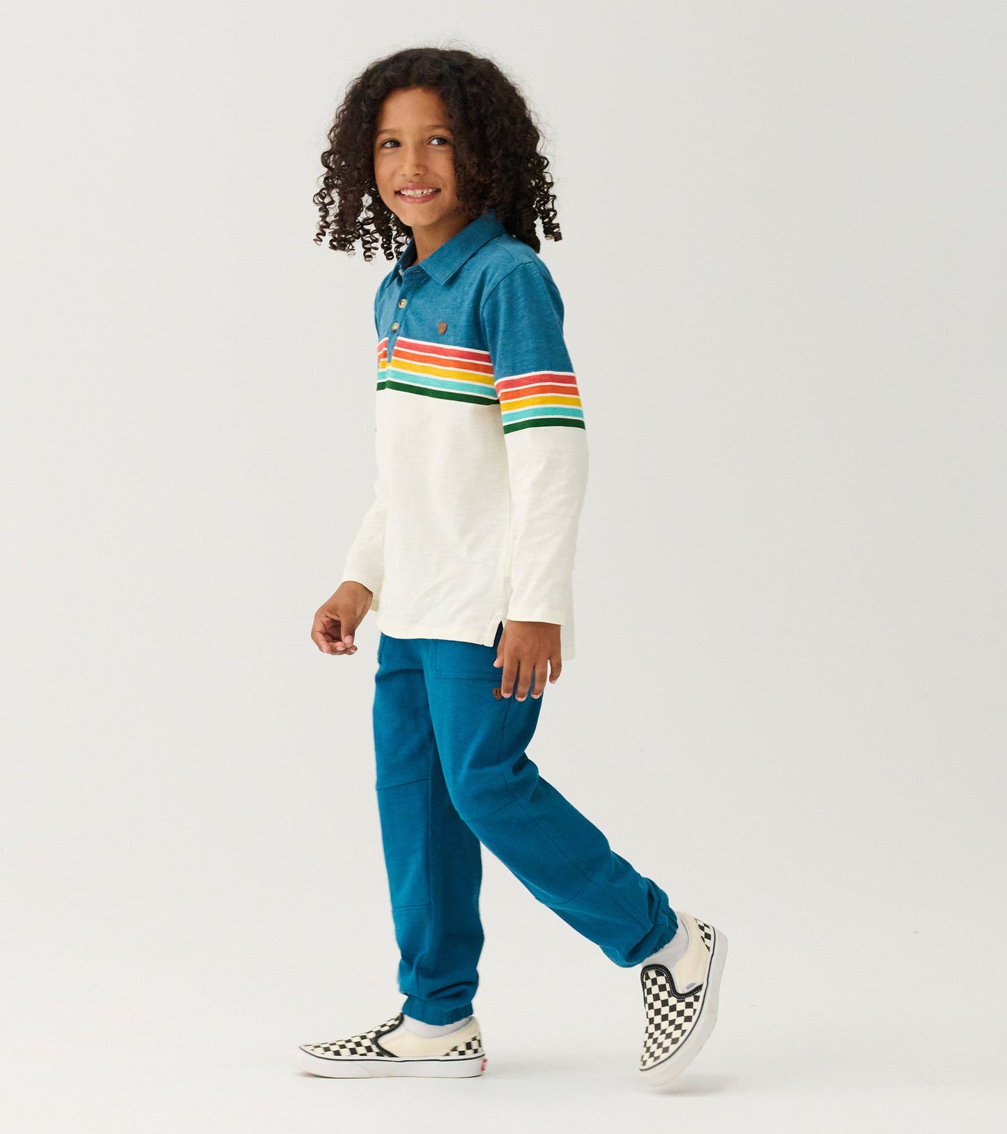 Long sleeve polo featuring a blue top with colorful retro stripes and a cream body, paired with blue pants.
