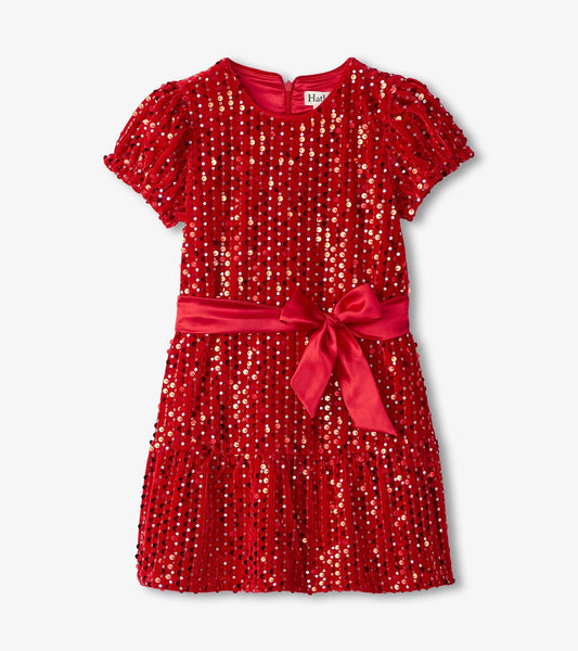 Red velvet dress adorned with sequins, short puff sleeves, and a satin bow at the waist. Flared skirt design.