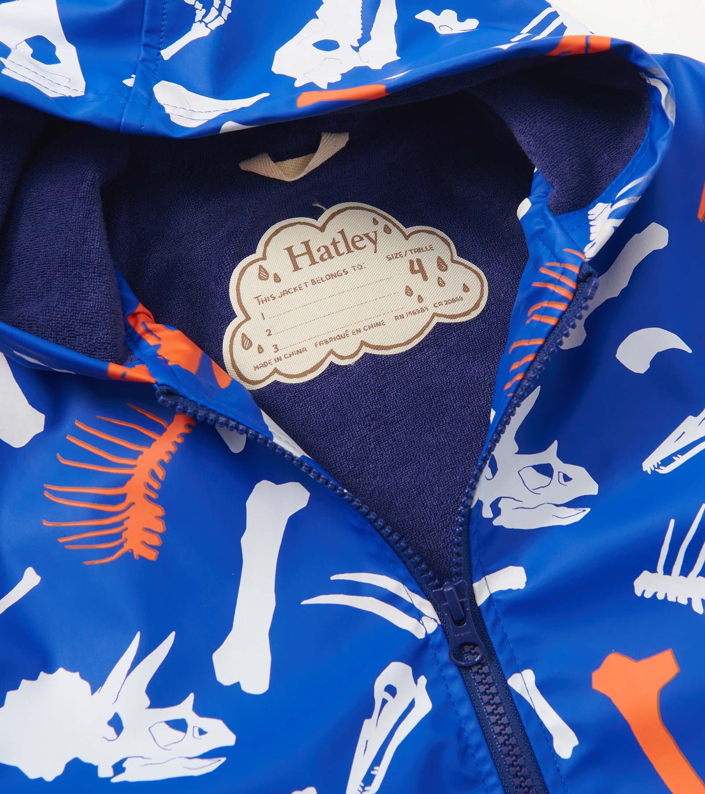 Blue zip-up rain jacket featuring white and orange dinosaur fossil prints, with a soft interior lining.