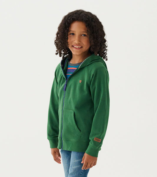 Green zip-up hoodie with a hood, front pockets, and a small emblem, worn by a child with curly hair.