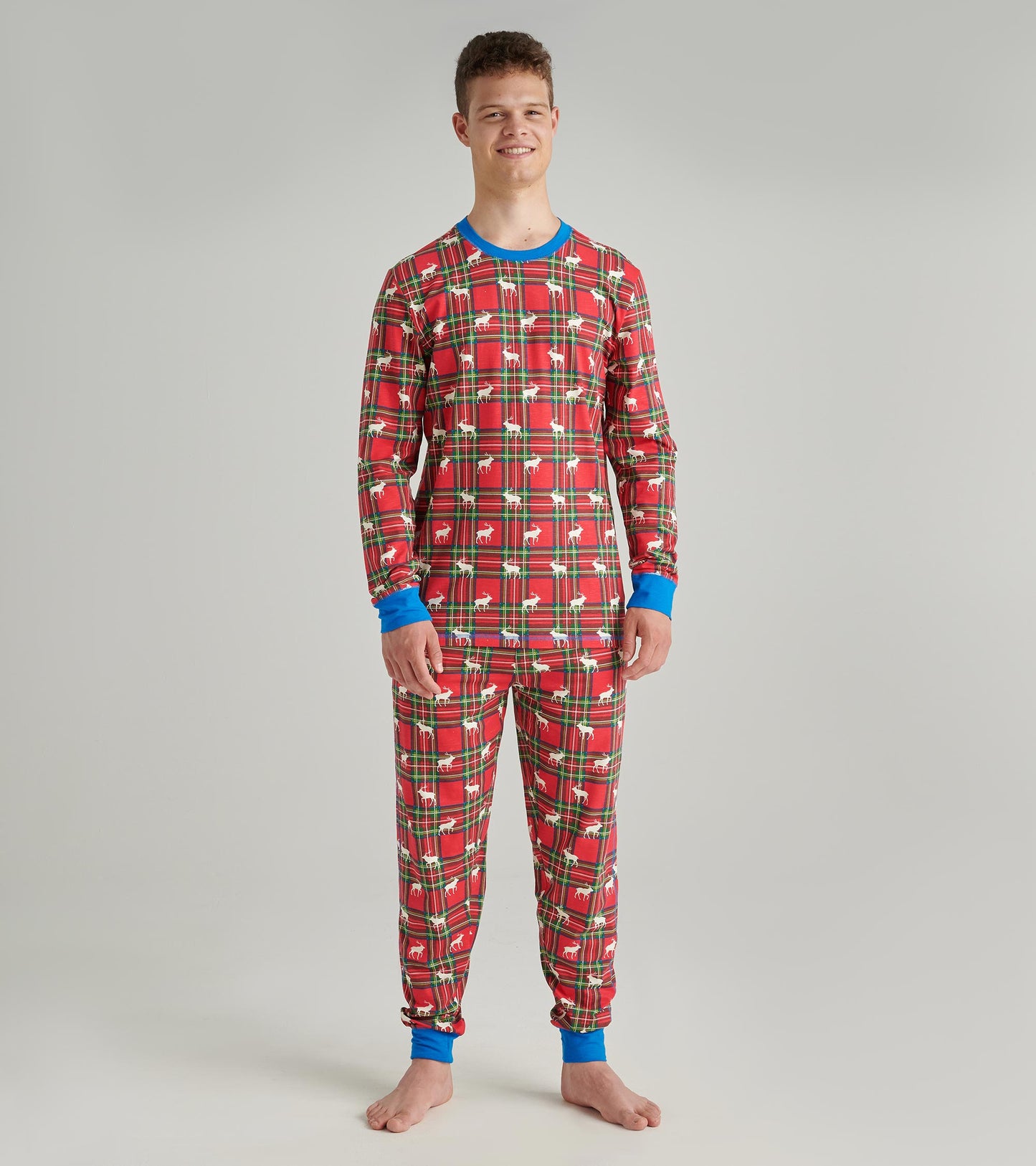 Red plaid pajama set featuring blue cuffs, with a festive pattern of deer and trees, suitable for lounging or sleeping.