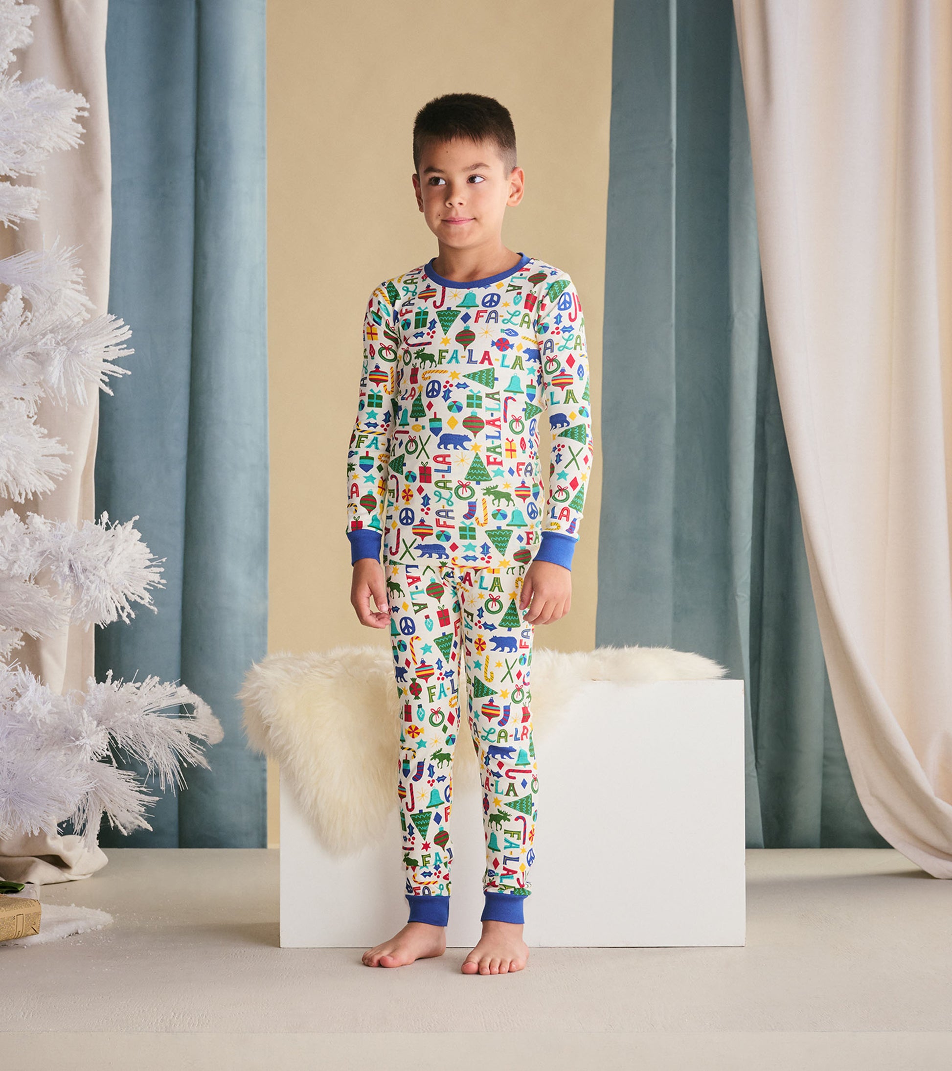 Colorful boys' pajama set featuring festive patterns, long sleeves, and blue cuffs, suitable for sleepwear.