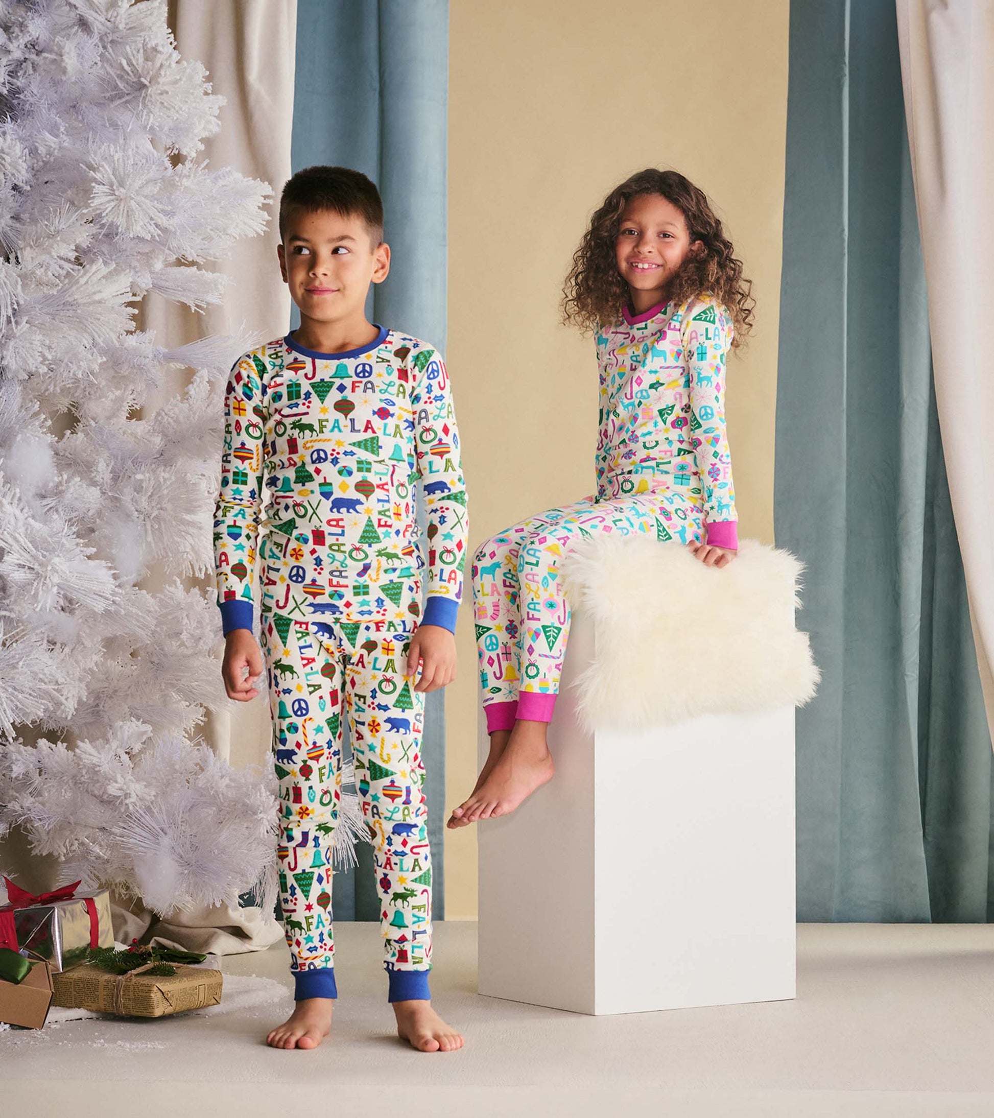 Colorful pajama set featuring playful patterns, long sleeves, and ribbed cuffs, worn by a boy and girl.