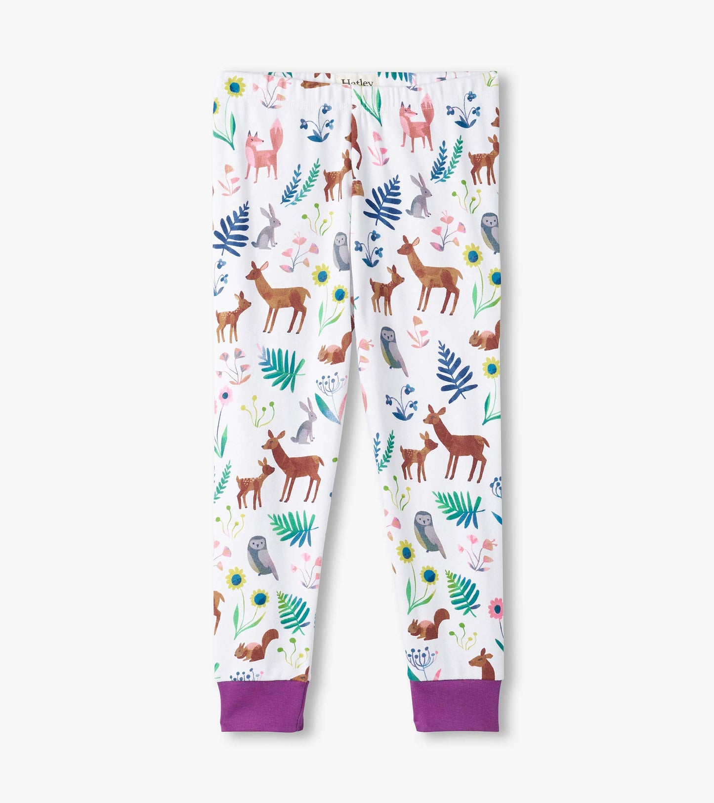 White pajama pants featuring colorful forest creatures and floral patterns, with purple cuffs at the ankles.