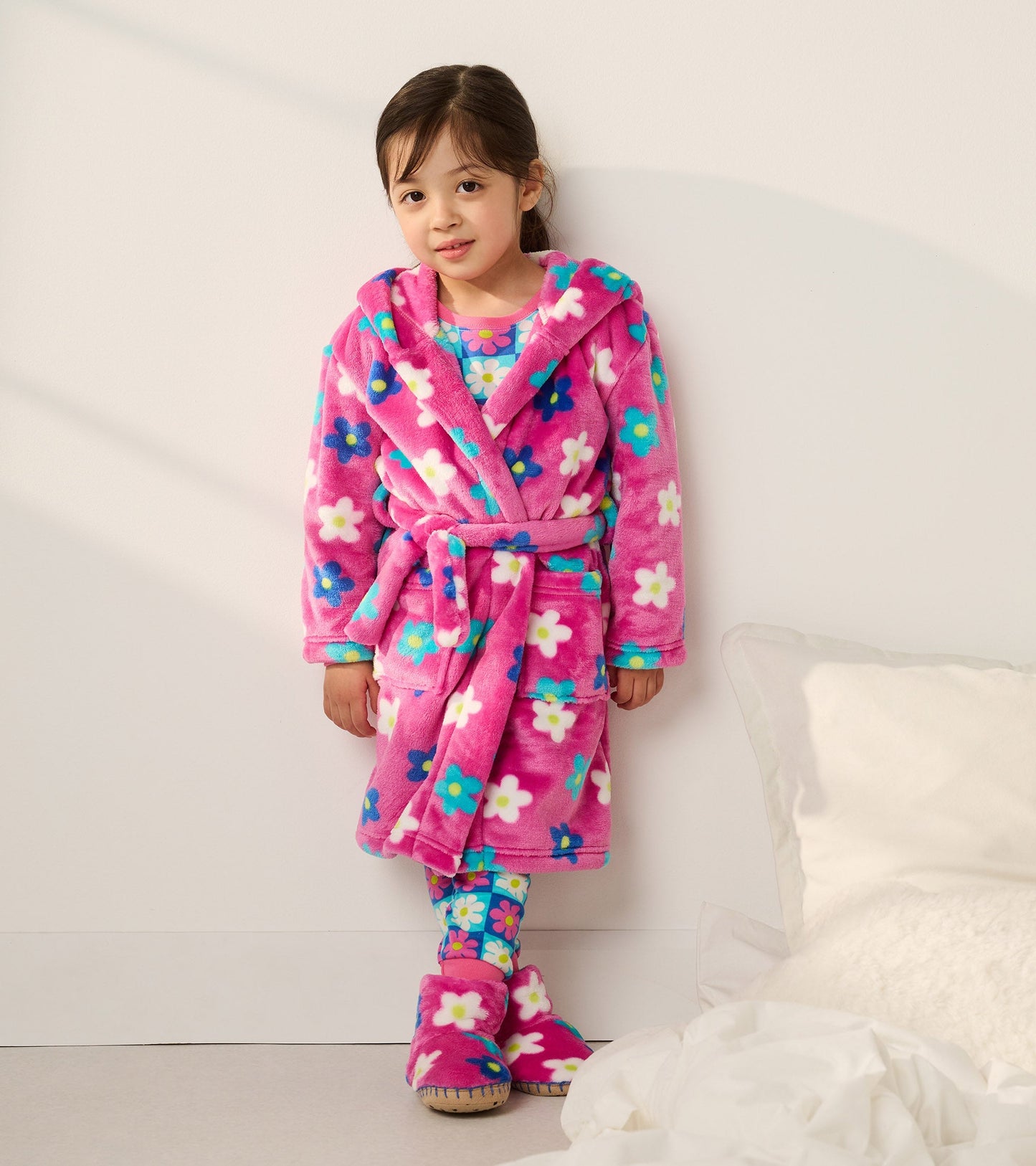 Pink fleece robe with floral pattern, hood, and belt, worn by a girl with matching floral leggings and slippers.