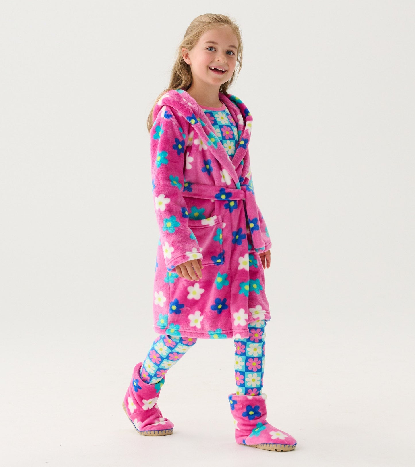 Pink fleece robe with colorful daisy pattern, featuring a hood and belt, worn by a girl with matching leggings and slippers.