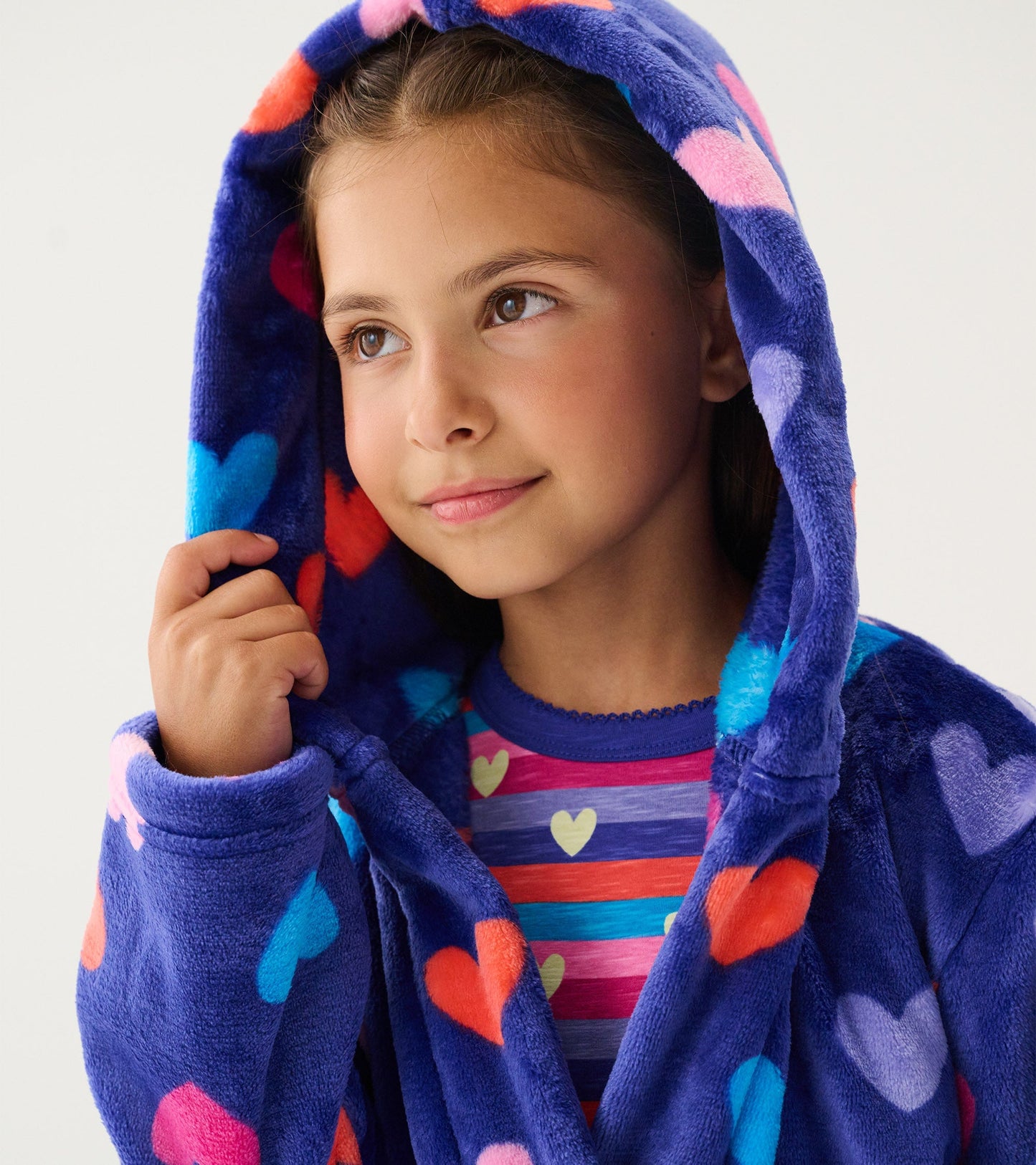 Purple fleece robe with colorful heart patterns, featuring a hood and a cozy fit, worn by a young girl.
