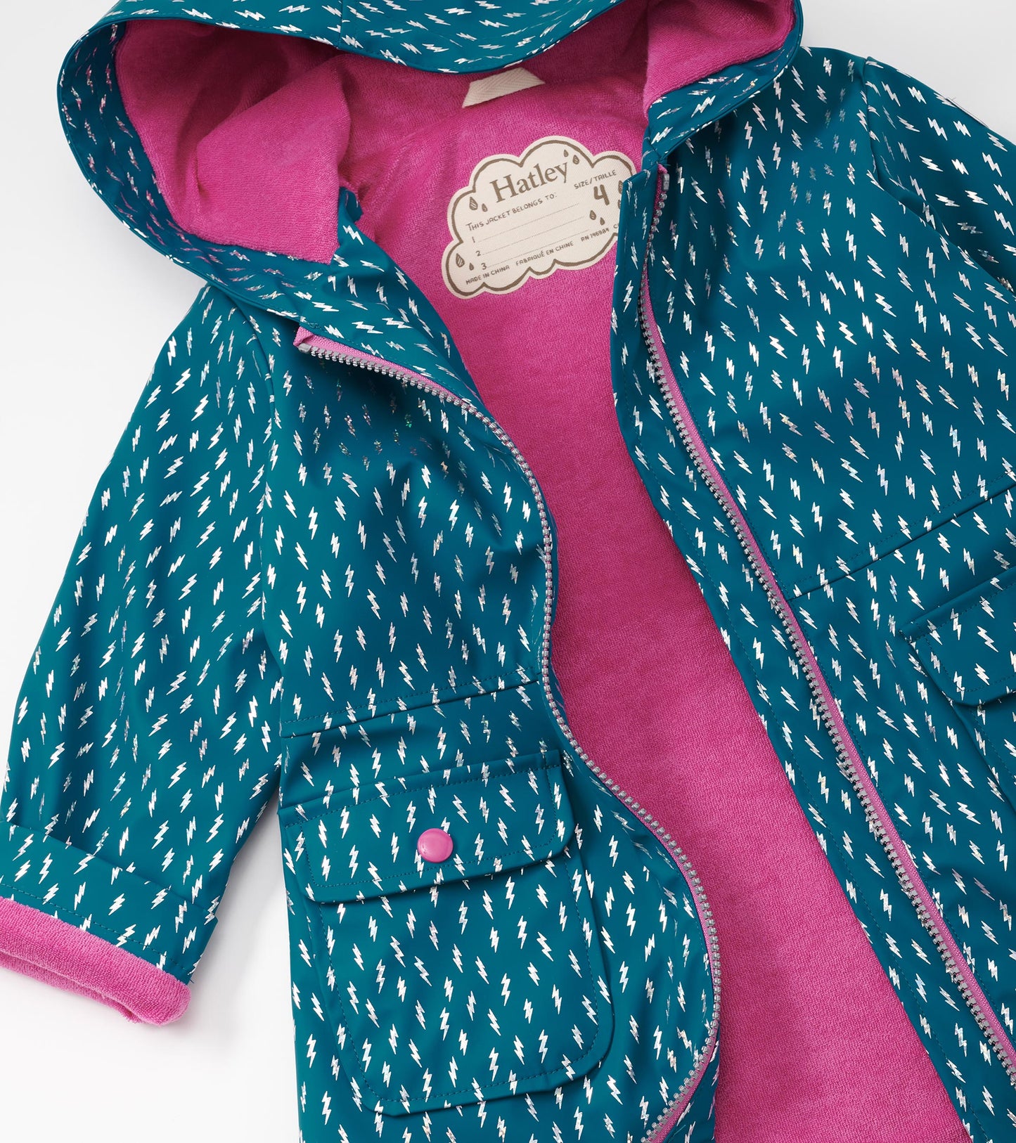 Teal rain jacket with white lightning bolt pattern, pink lining, zip-up front, and two front pockets.