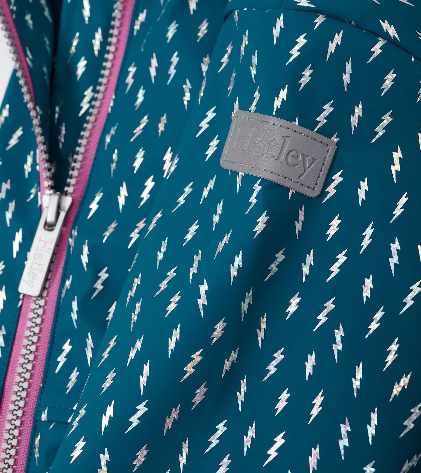 Teal zip-up rain jacket featuring metallic lightning bolt pattern and a contrasting pink zipper.