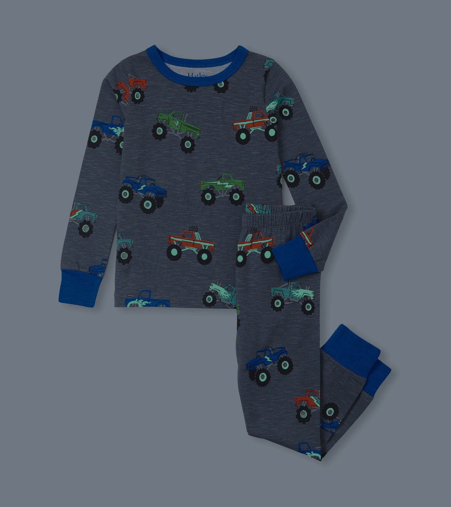 Gray pajama set featuring colorful monster truck prints, long sleeves, and elastic waistband pants.