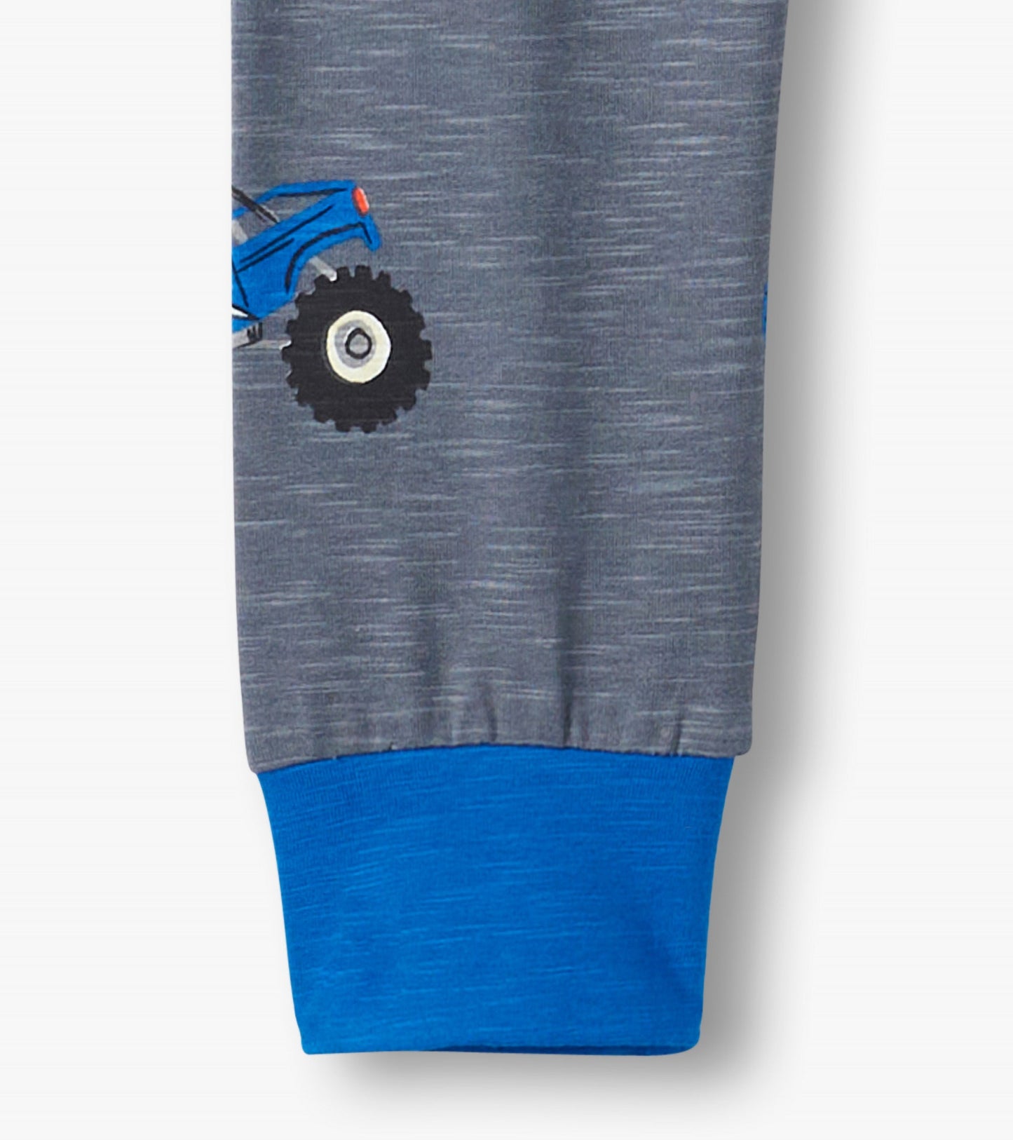 Gray pajama set featuring blue cuffs and a monster truck design on the leg. Soft material for comfort.