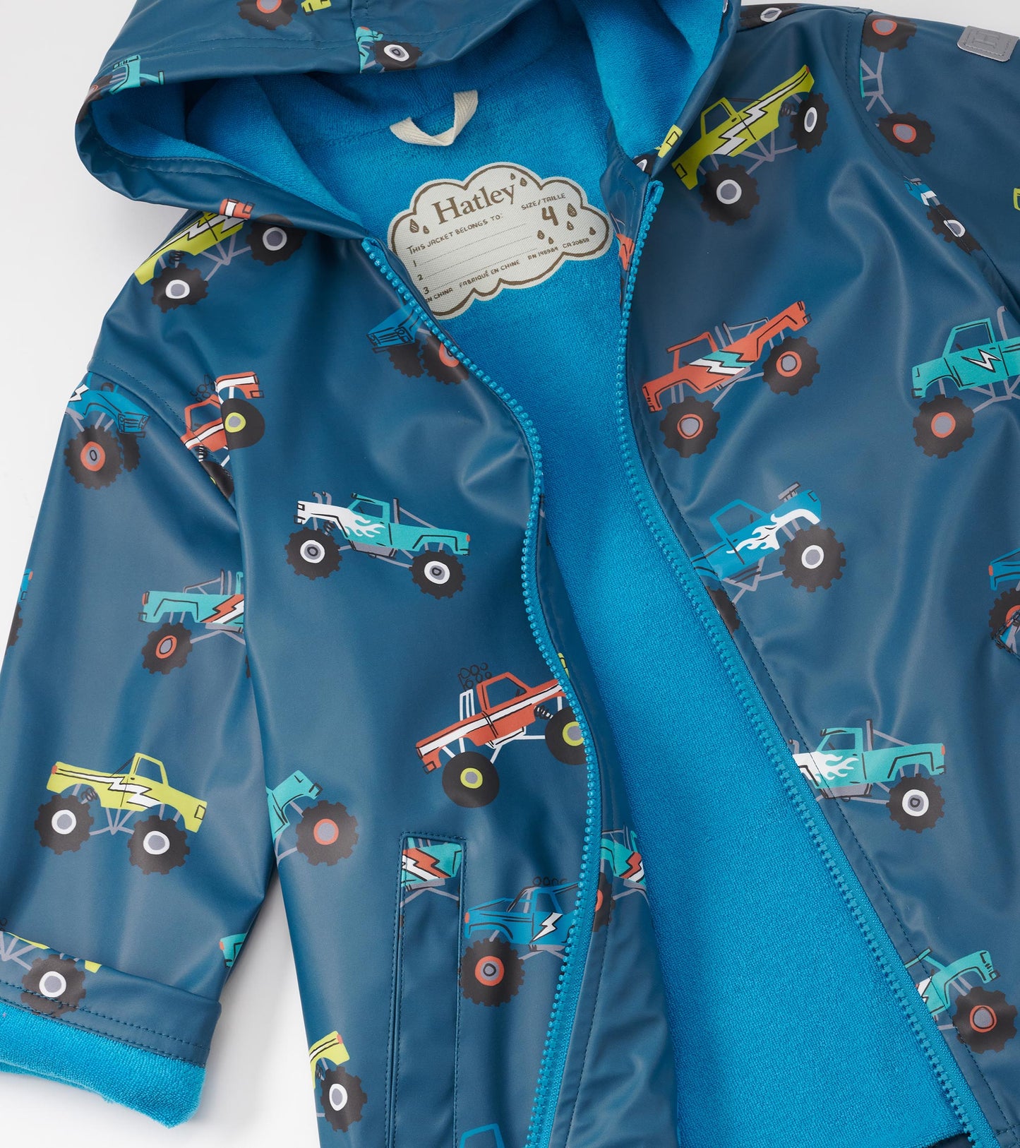 Blue zip-up rain jacket featuring colorful monster truck patterns and a soft inner lining.