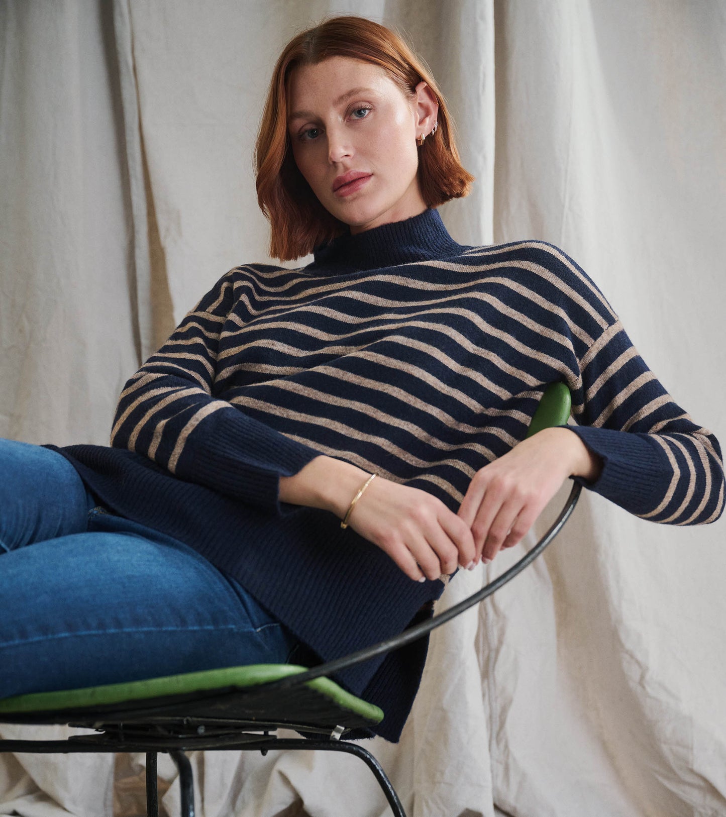 Navy tunic with taupe stripes and a mock neck, featuring a relaxed fit and ribbed hem, styled with jeans.