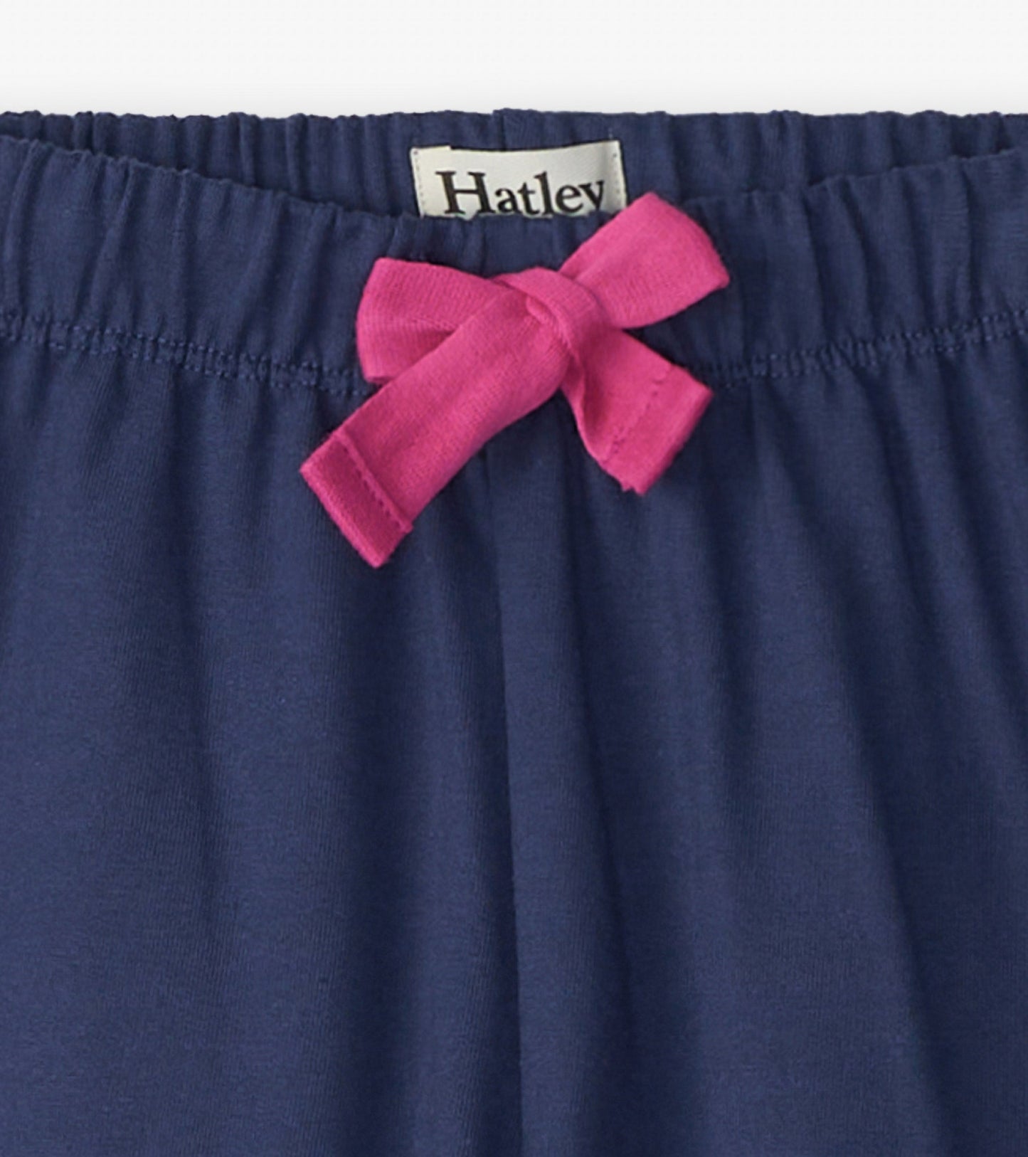 Navy baggy track pants featuring a pink bow at the waistband, made from soft, comfortable fabric.