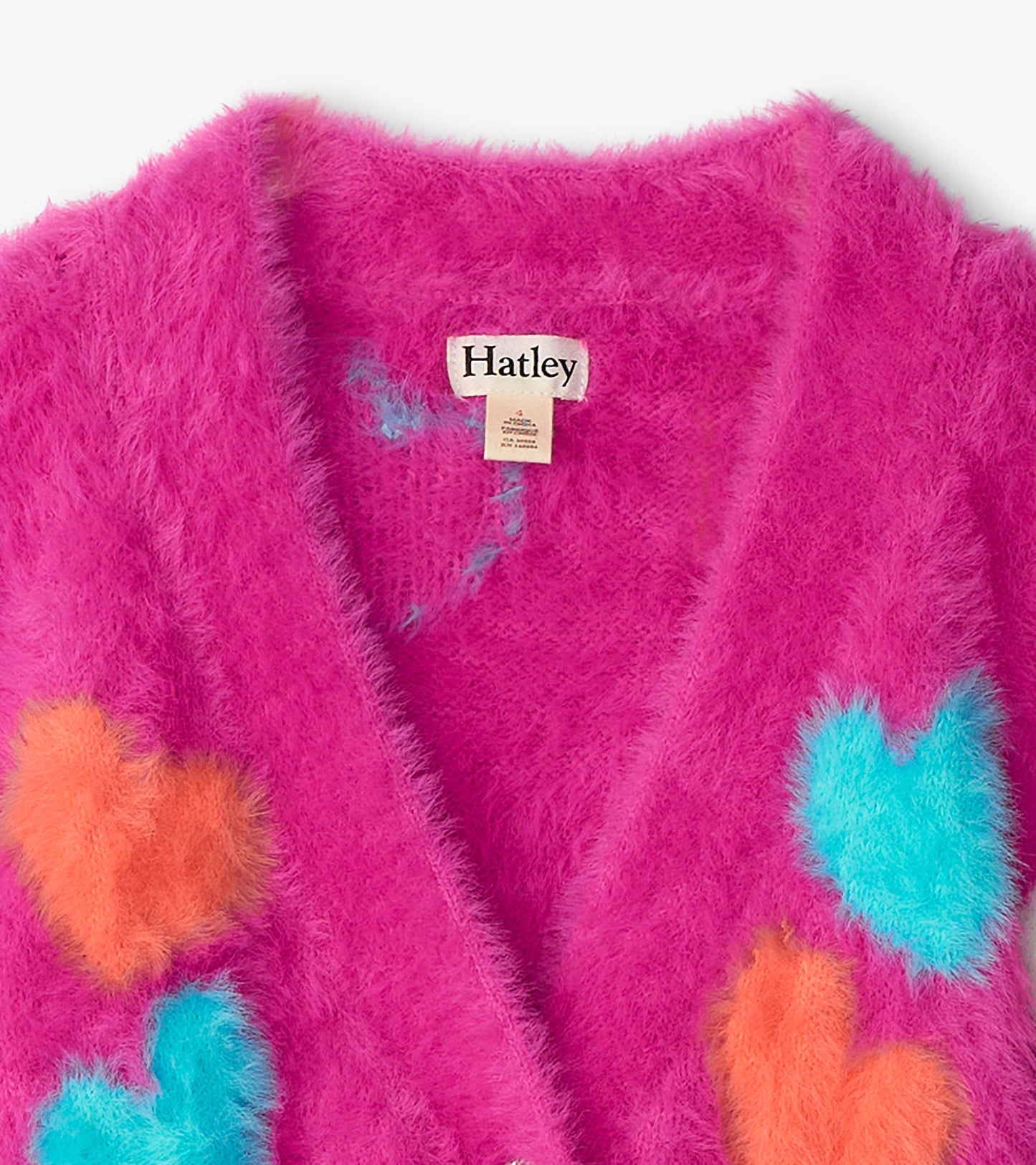 Fuzzy pink cardigan featuring colorful heart patterns in orange and blue, designed for girls.