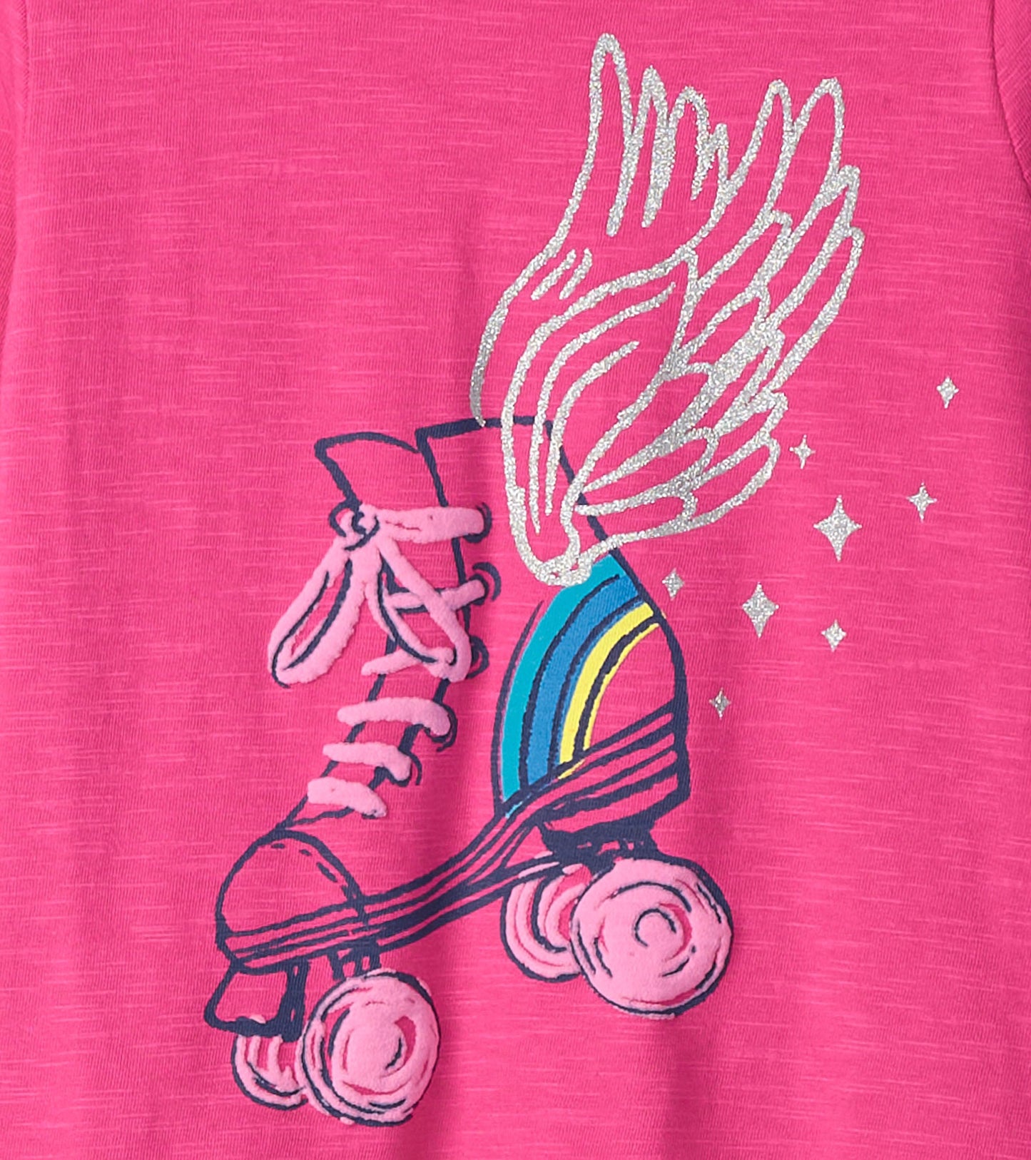 Pink long sleeve tee featuring a graphic of roller skates with wings and a rainbow, embellished with glitter accents.
