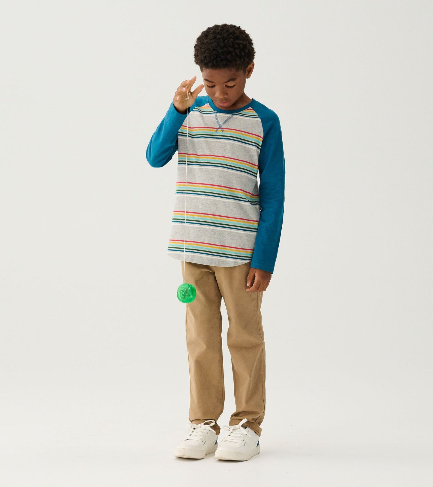 Long sleeve raglan T-shirt featuring gray body with colorful stripes and blue sleeves, worn with khaki pants.