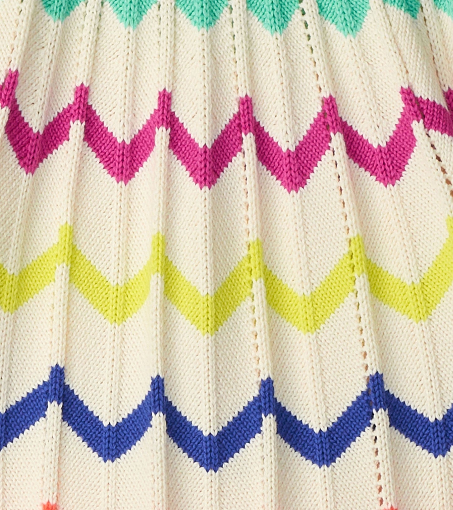 Knitted sweater featuring a chevron pattern in vibrant colors: pink, green, yellow, and blue on a cream background.