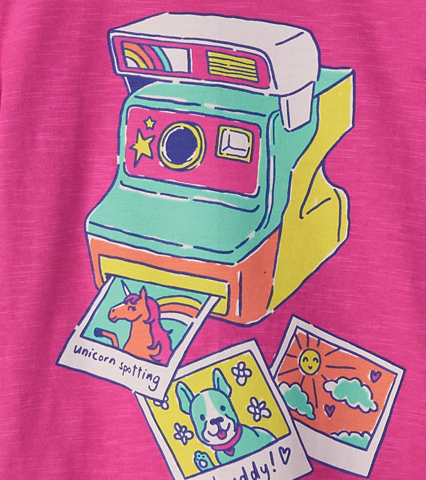 Bright pink tee featuring a colorful graphic of a vintage camera with photo prints of a unicorn and a dog.