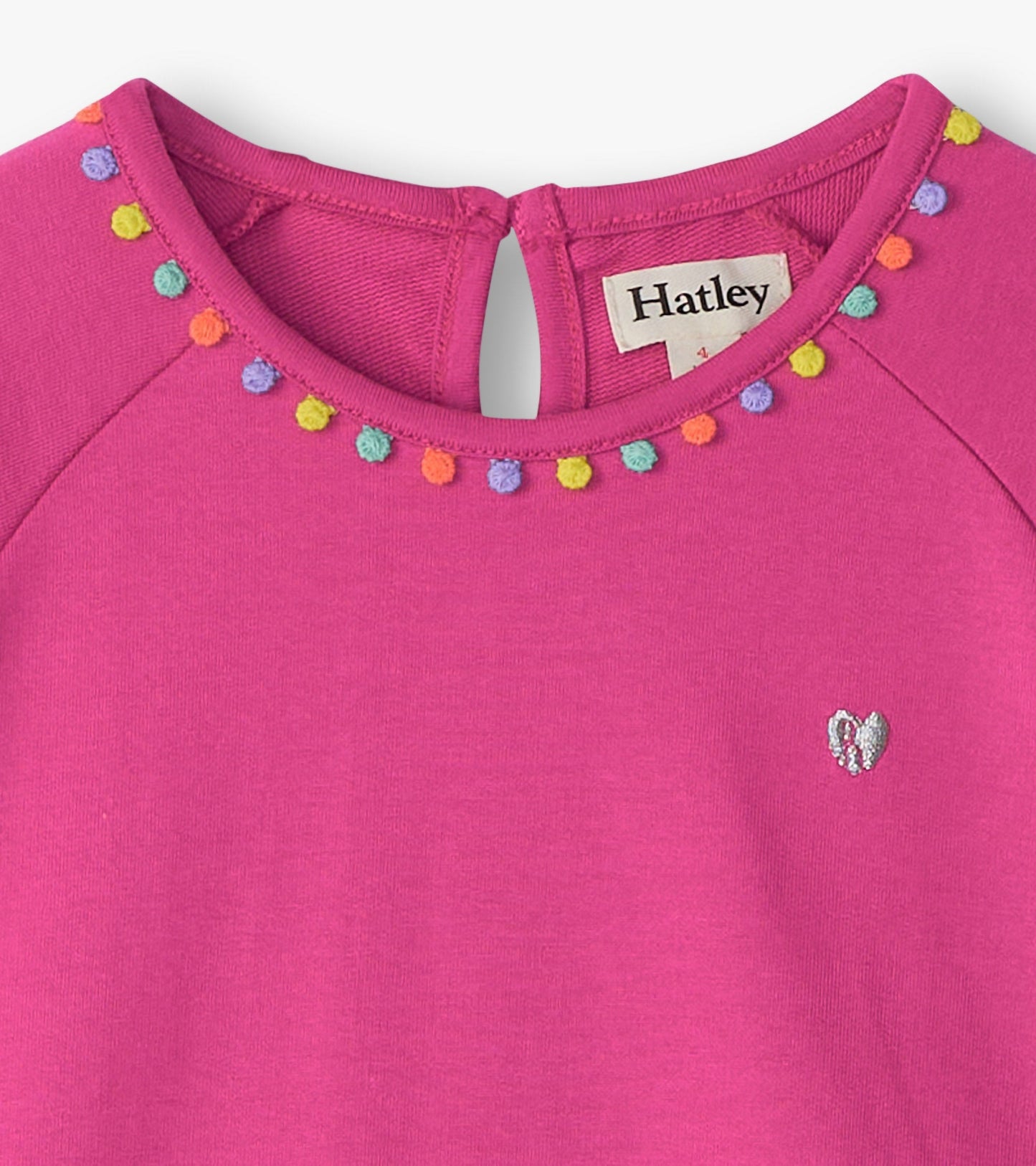 Bright pink dress featuring a gathered tiered design with colorful pom-pom trim and a small heart embroidery.