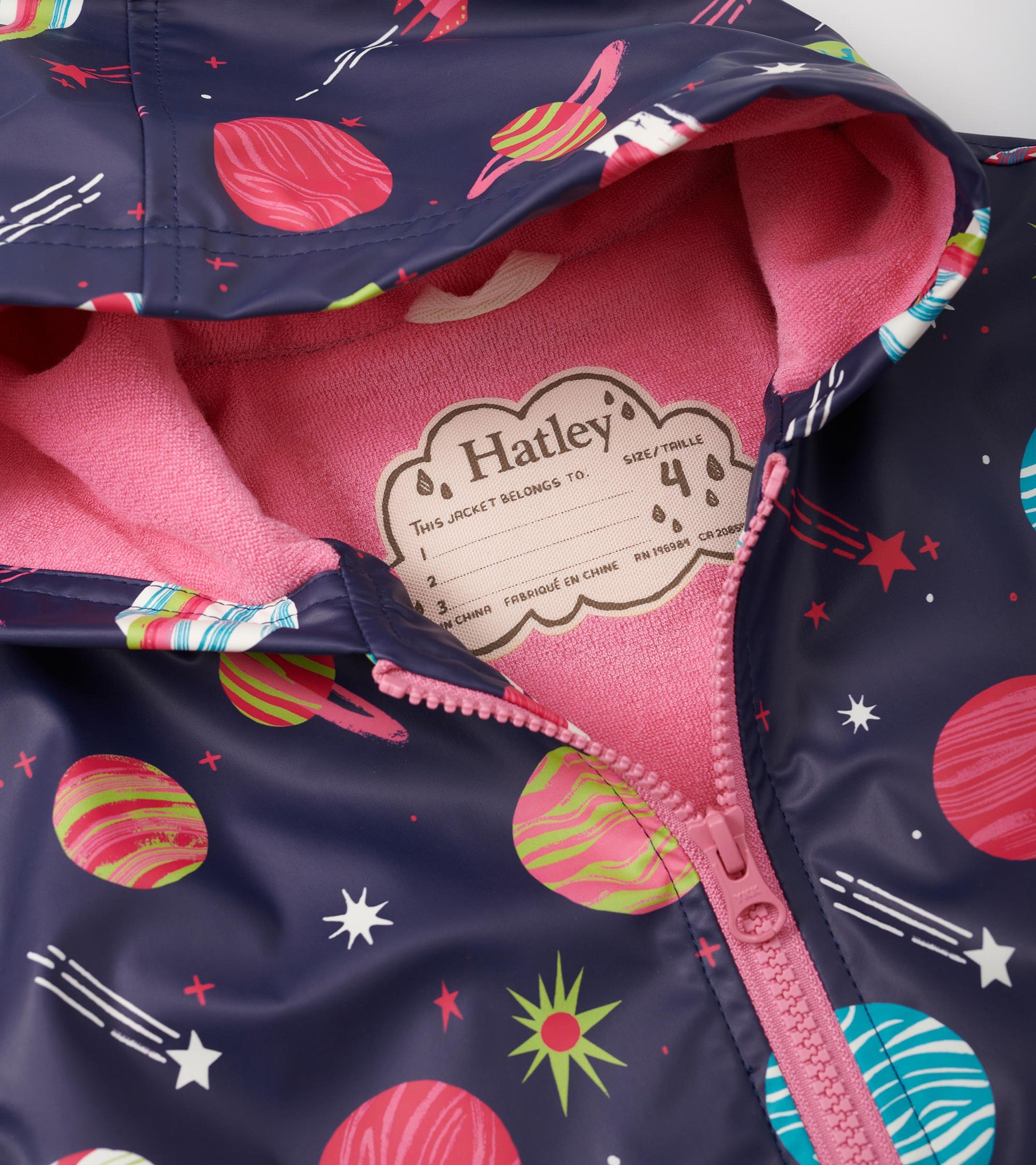 Navy rain jacket with colorful planet and star print, featuring a pink fleece lining and zip-up front.