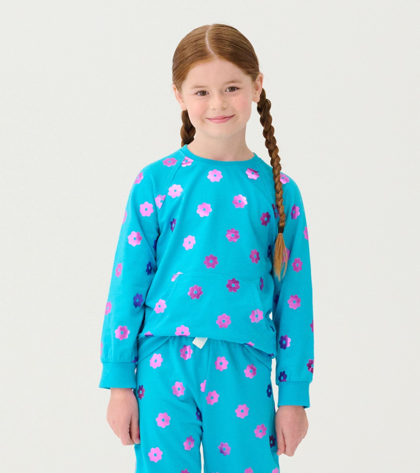 Turquoise sweater with pink and purple floral pattern, featuring long sleeves and a relaxed fit.