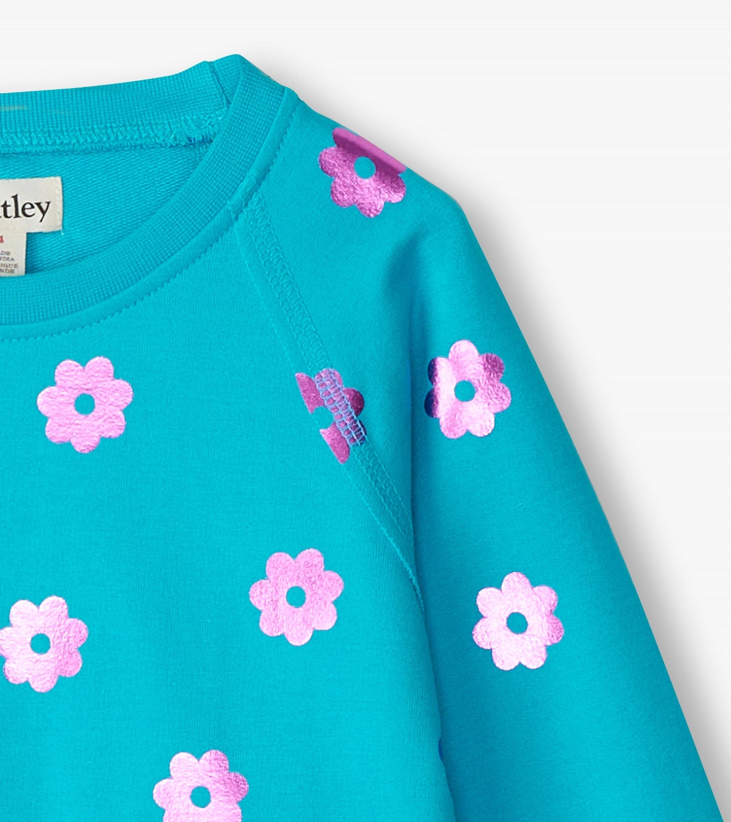 Turquoise sweater featuring pink floral patterns, round neckline, and long sleeves.
