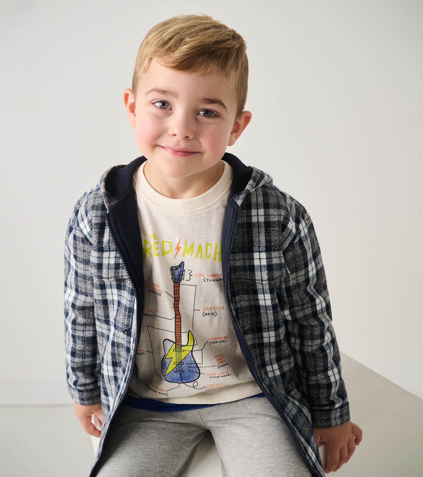 Hooded jacket with a navy and gray plaid pattern, featuring a soft lining, worn by a boy with a graphic t-shirt.