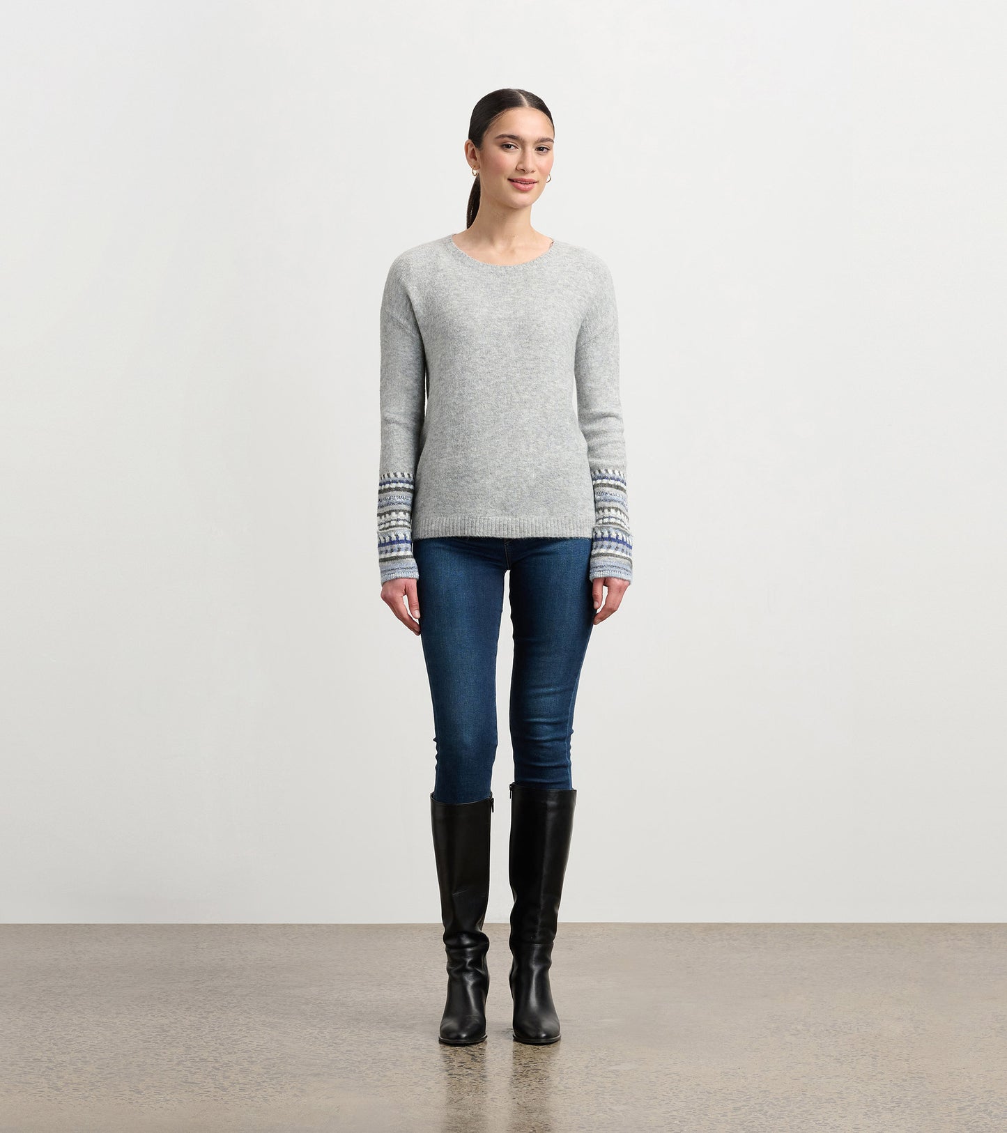 Grey melange sweater with jacquard patterned cuffs, featuring a crew neckline and a fitted silhouette.