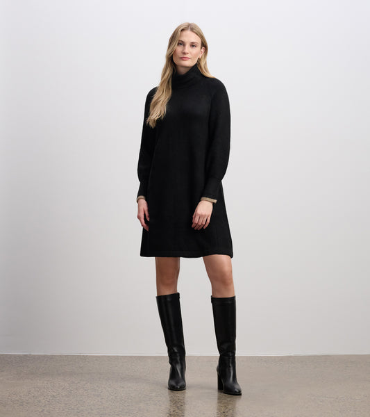 Black swing sweater dress with a high neckline and long sleeves, styled with knee-high black boots.