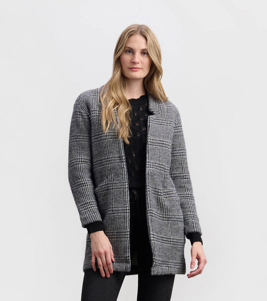 Cozy black check open blazer with long sleeves and front pockets, styled over a black top and paired with dark jeans.