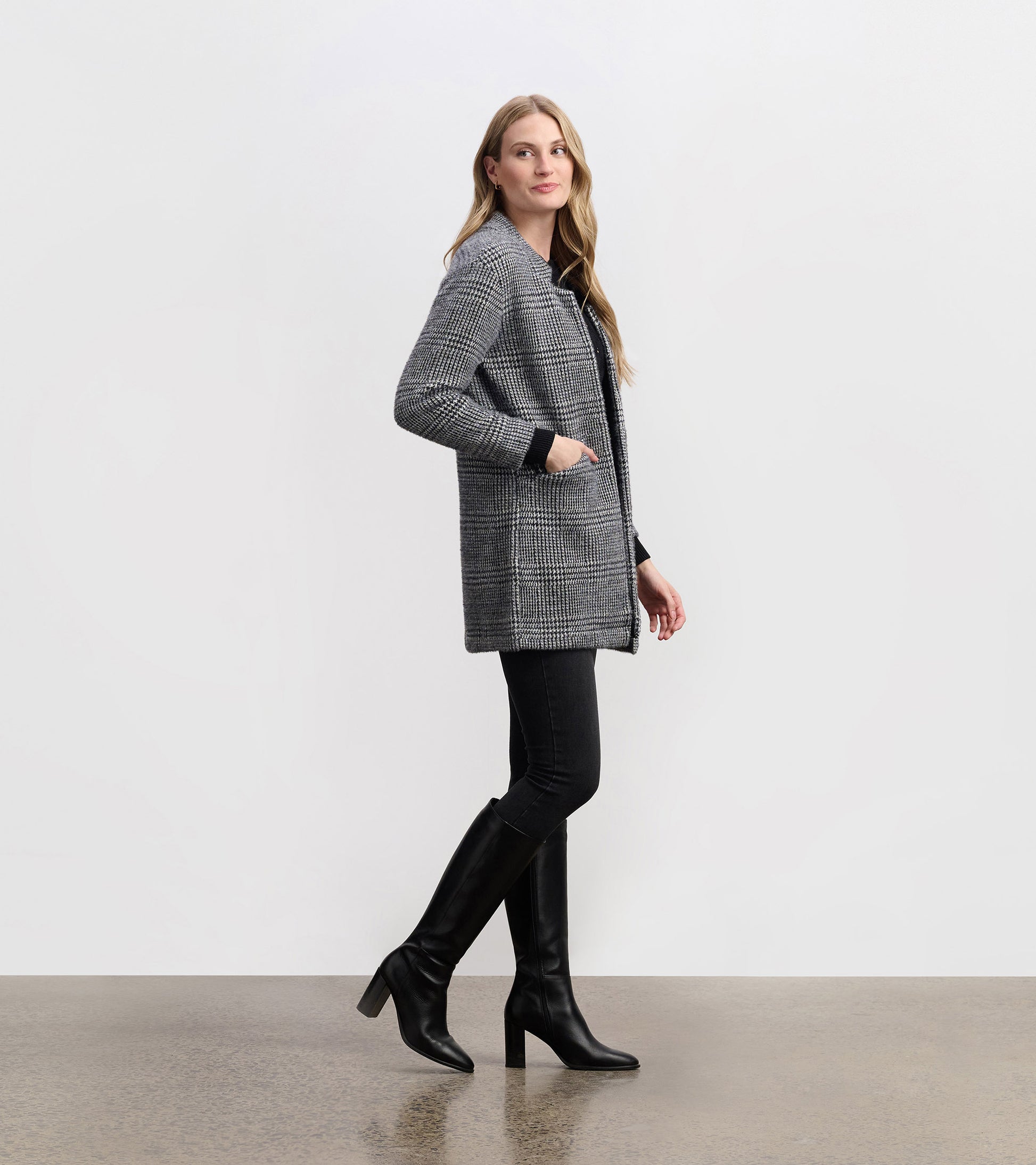 Cozy black check blazer with a relaxed fit, featuring pockets and a collar, styled with black jeans and knee-high boots.