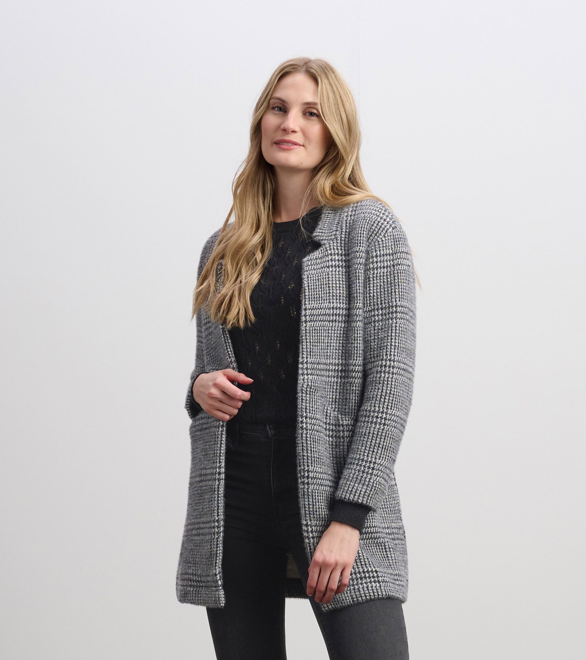 Cozy black check open blazer with long sleeves, featuring a relaxed fit and front pockets, styled over a black top.